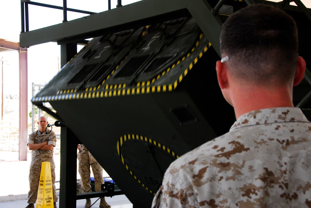 The first group of Humvee Egress Assistance Trainer instructors for Marine Corps Air Station in Yuma, Ariz. examines the new simulator May 8, 2009. Staff Sgt. Frank Villaverde, a combat instructor from Marine Corps Air Ground Combat Center Twentynine Palms, Calif. visited the station to give 16 student instructors from around station the HEAT class and walk them through the training. The instructors will be qualified for the next two years to train Marines in their units prior to deployment.