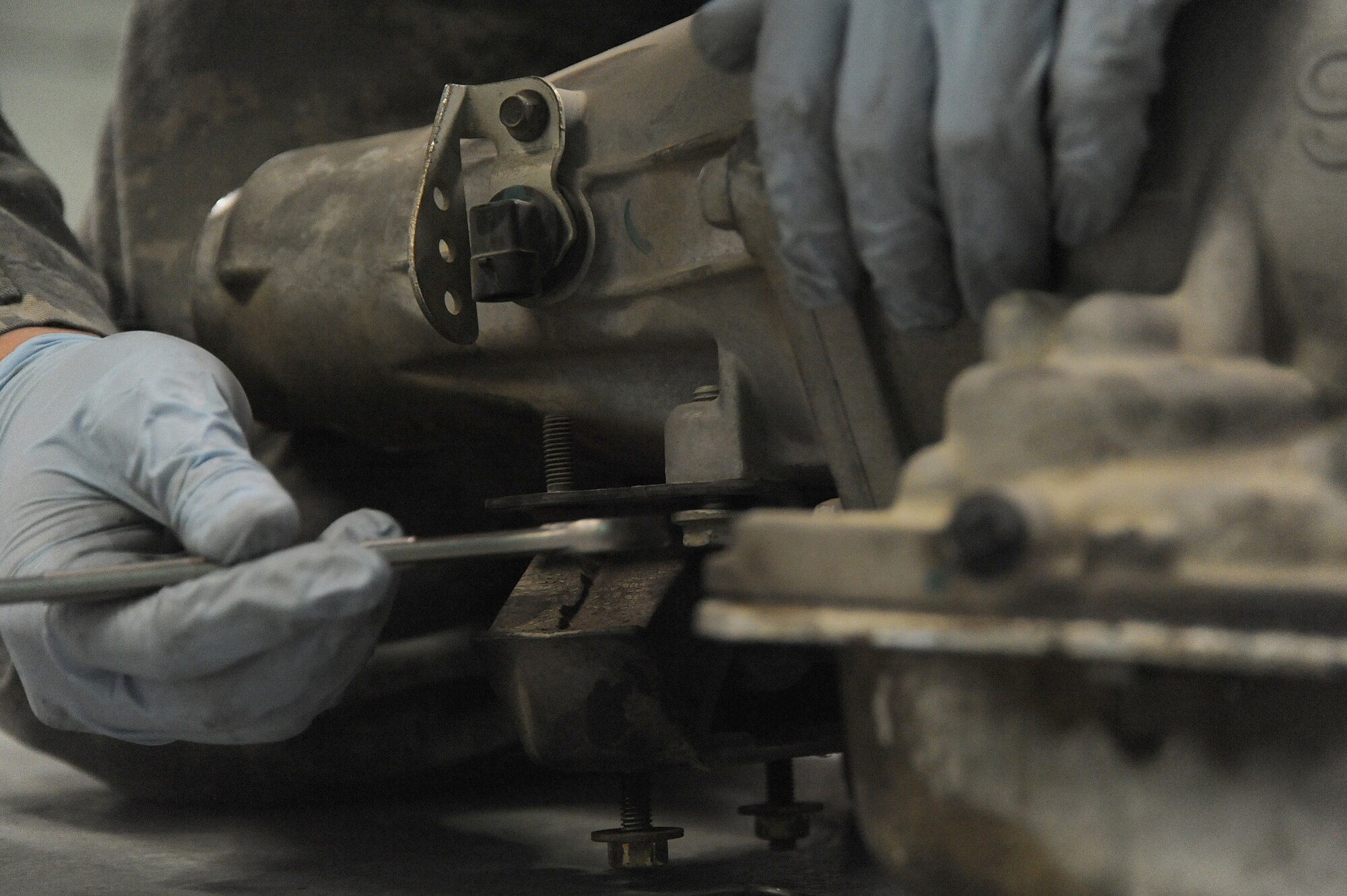 Senior Airman Michael Jakubec, 380th Expeditionary Logistics Readiness Squadron, vehicle maintenance, removes a bracket from an old transmission to be used on a new transmission for a Pontiac GTO, April 26 at an undisclosed location in Southwest Asia. The GTO is used as a chase car to help guide the U-2 Dragon Lady pilots during take-offs and landings. Airman Jakubec is deployed from Kadena AB, Japan and hails from Spanaway Wash.  (U.S. Air Force photo by Senior Airman Brian J. Ellis) (Released)