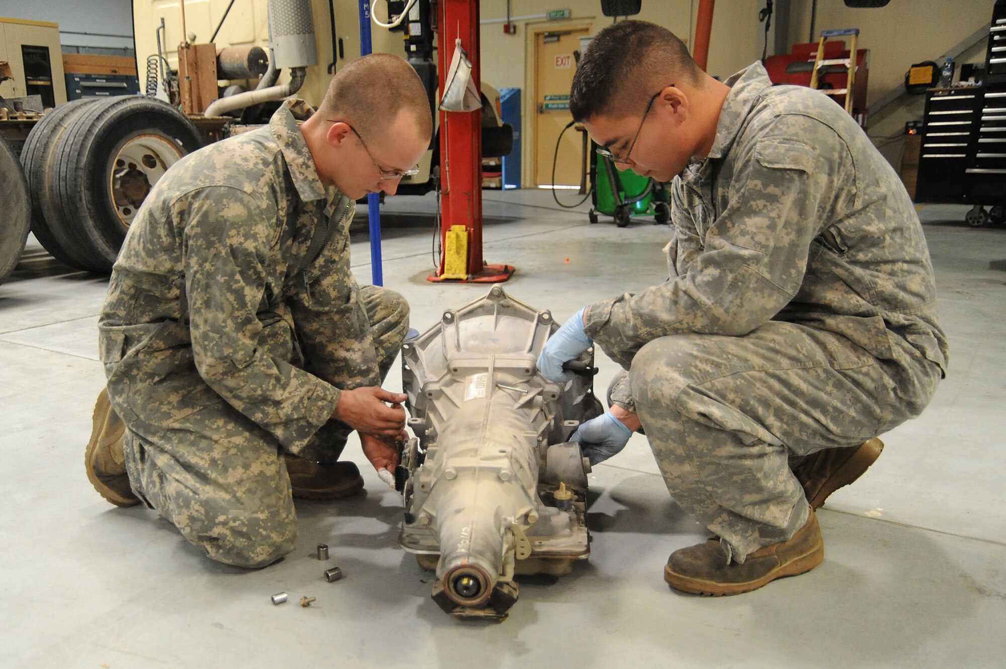 Senior Airman Adam Owens and Senior Airman Michael Jakubec, 380th Expeditionary Logistics Readiness Squadron, vehicle maintenance, remove brackets and sensors from an old transmission to be used on a new transmission for a Pontiac GTO, April 26 at an undisclosed location in Southwest Asia. The GTO is used as a chase car to help guide the U-2 Dragon Lady pilots during take-offs and landings. Airman Owens is deployed from 174th Air National Guard Base, Hancock Field, N.Y. and hails from Binghamton, N.Y. Airman Jakubec is deployed from Kadena AB, Japan and hails from Spanaway Wash.  (U.S. Air Force photo by Senior Airman Brian J. Ellis) (Released)