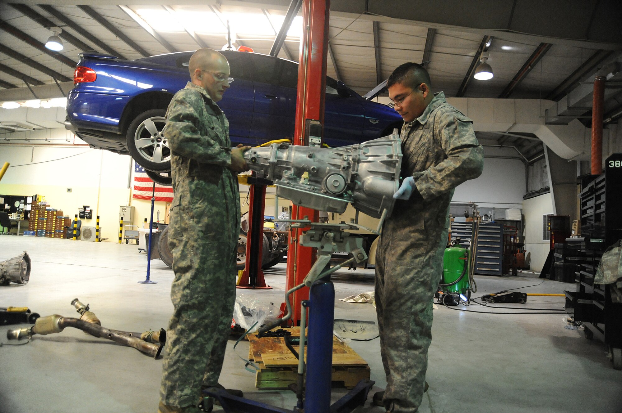 Senior Airman Adam Owens and Senior Airman Michael Jakubec, 380th Expeditionary Logistics Readiness Squadron, vehicle maintenance, lift a transmission onto a transmission jack so that it can be raised into a Pontiac GTO, April 26 at an undisclosed location in Southwest Asia. The GTO is used as a chase car to help guide the U-2 Dragon Lady pilots during take-offs and landings. Airman Owens is deployed from 174th Air National Guard Base, Hancock Field, N.Y. and hails from Binghamton, N.Y. Airman Jakubec is deployed from Kadena AB, Japan and hails from Spanaway Wash.  (U.S. Air Force photo by Senior Airman Brian J. Ellis) (Released)