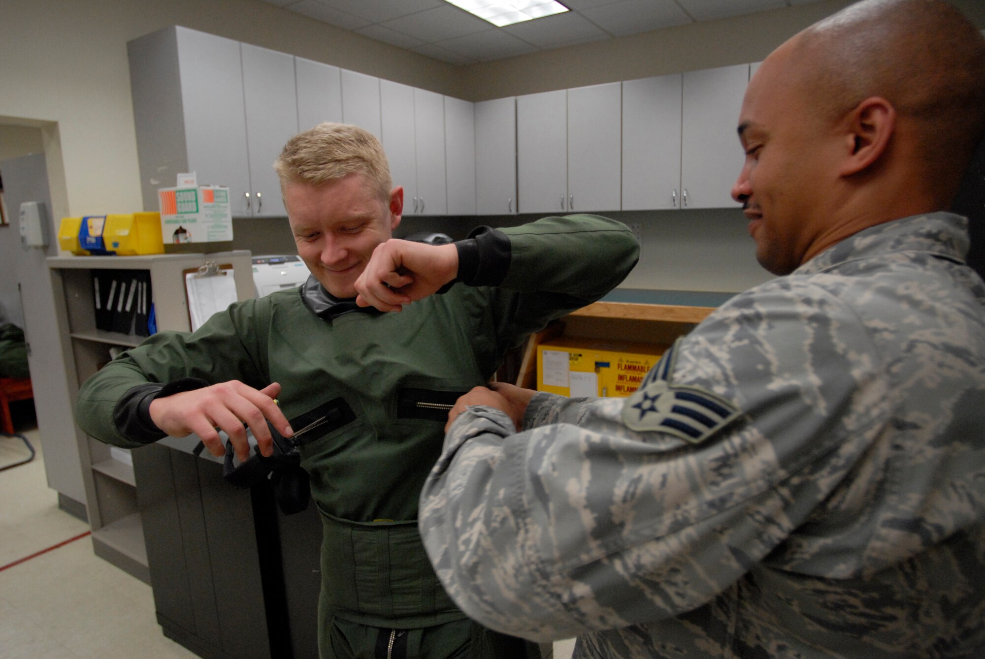 Senior Airman Stephen Slack, aircrew flight equipment technician assigned to the 8th Operations Support Squadron, helps Capt. Jerad Hand, a pilot with the 80th Fighter Squadron, into his anti-exposure suit at Kunsan Air Base, Republic of Korea. Aircrew flight technicians are responsible for all of the equipment that will save a pilots life in the event of an ejection from the aircraft. (U.S. Air Force Photo by Staff Sgt Jason Colbert)

