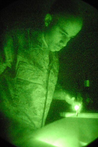 Staff Sgt. Ronnie Hester, an aircrew flight equipment technician assigned to the 8th Operations Support Squadron, checks a technical order while performing an operations check on a pair of night vision goggles at Kunsan Air Base, Republic of Korea. Aircrew flight equipment technicians are responsible for all of the equipment that will save a pilot's life in the event the pilot has to eject from the aircraft. (U.S. Air Force Photo by Staff Sgt Jason Colbert)


