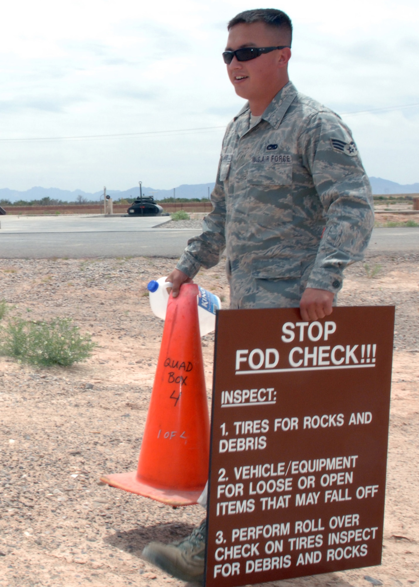 Senior Airman Steven Holland, 49th Maintenance Squadron, posts a sign to inform drivers entering the flight line of foreign object debris inspection during the 49th Civil Engineering Squadron's FOD Training Day at Holloman Air Force Base, N.M., May 1. Prior to entering the airfield environment, FOD checks are performed to ensure the safety of personnel and equipment. (U.S. Air Force photo/ Airman 1st Class Veronica Stamps)