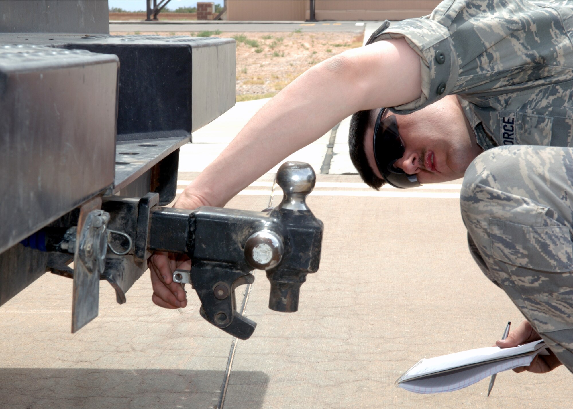 Staff Sgt. James Porte, 49th Maintenance Squadron, finds a loose item under a trailer hitch during the Civil Engineering Squadron's FOD Training Day at Holloman Air Force Base, N.M., May 1. The FOD Training Day was conducted to inform Airmen about what to look for when entering the flight line. (U.S. Air Force photo/ Airman 1st Class Veronica Stamps)