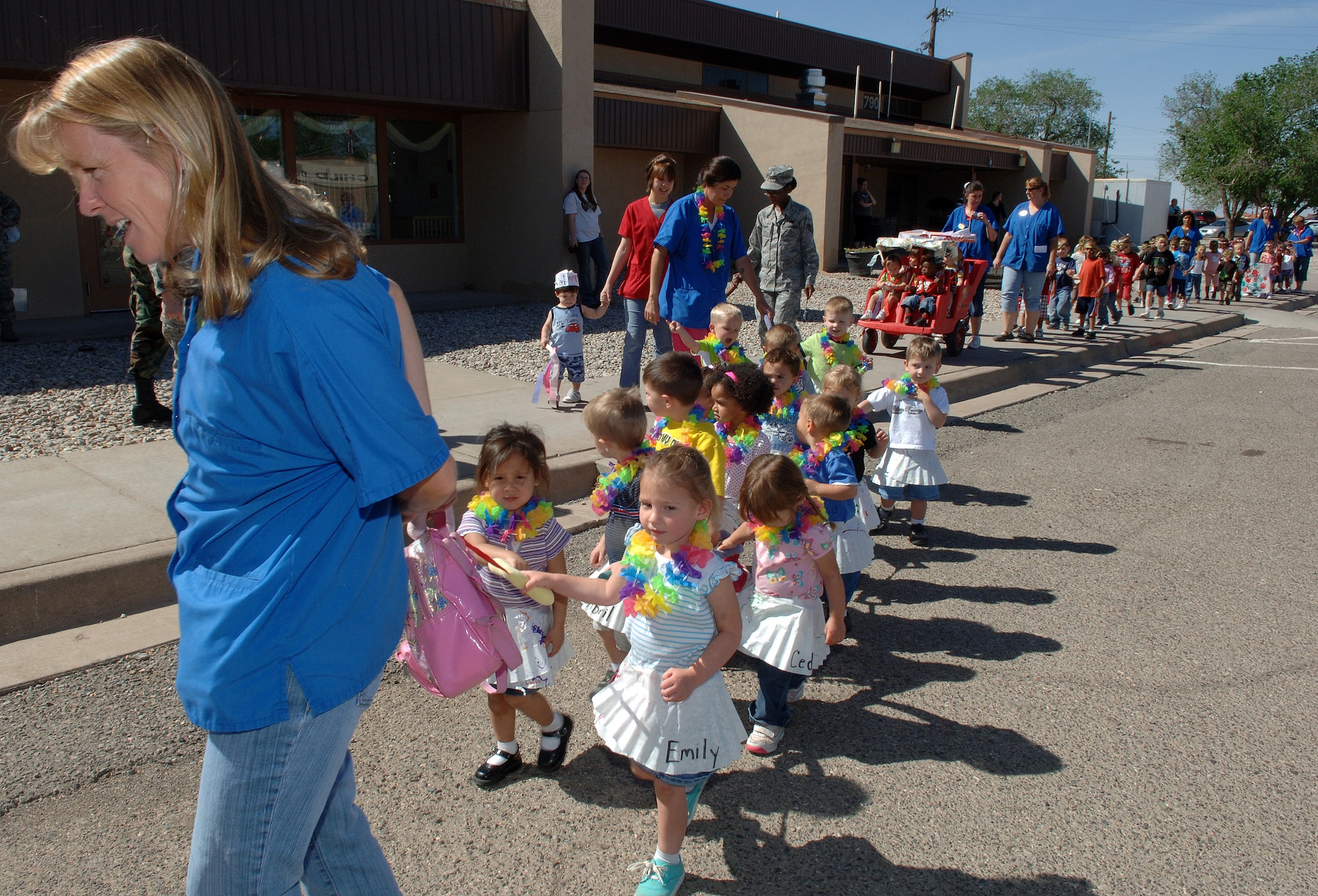 Mrs. Pauline Atkinson, Child Development Center caregiver, leads the pack of Hawaii-themed children dressed in grass skirts and leis during the Military Child Parade held at Holloman Air Force Base, N.M., April 30. The CDC hosts an annual parade that celebrates children of all ages in the military. (U.S. Air Force photo/Airman 1st Class Veronica Stamps) 
 
