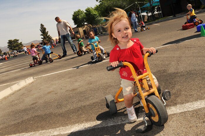 Madison Bower; daughter of Senior Airman Alexander Bower, an avionics technician currently serving a remote assignment with the 51st Fighter Wing at Osan Air Base, Korea; participates in the Child Development Center's tricycle-a-thon at Nellis Air Force Base, Nev., April 24. The event was one of many activities sponsored by the CDC in honor of the Month of Military Child in April, as designated by the Department of Defense. According to Military.com, more than 1.7 million children in America under the age of 18 have at least one parent serving in the military. (U. S. Air Force photo by Lawrence Crespo)
