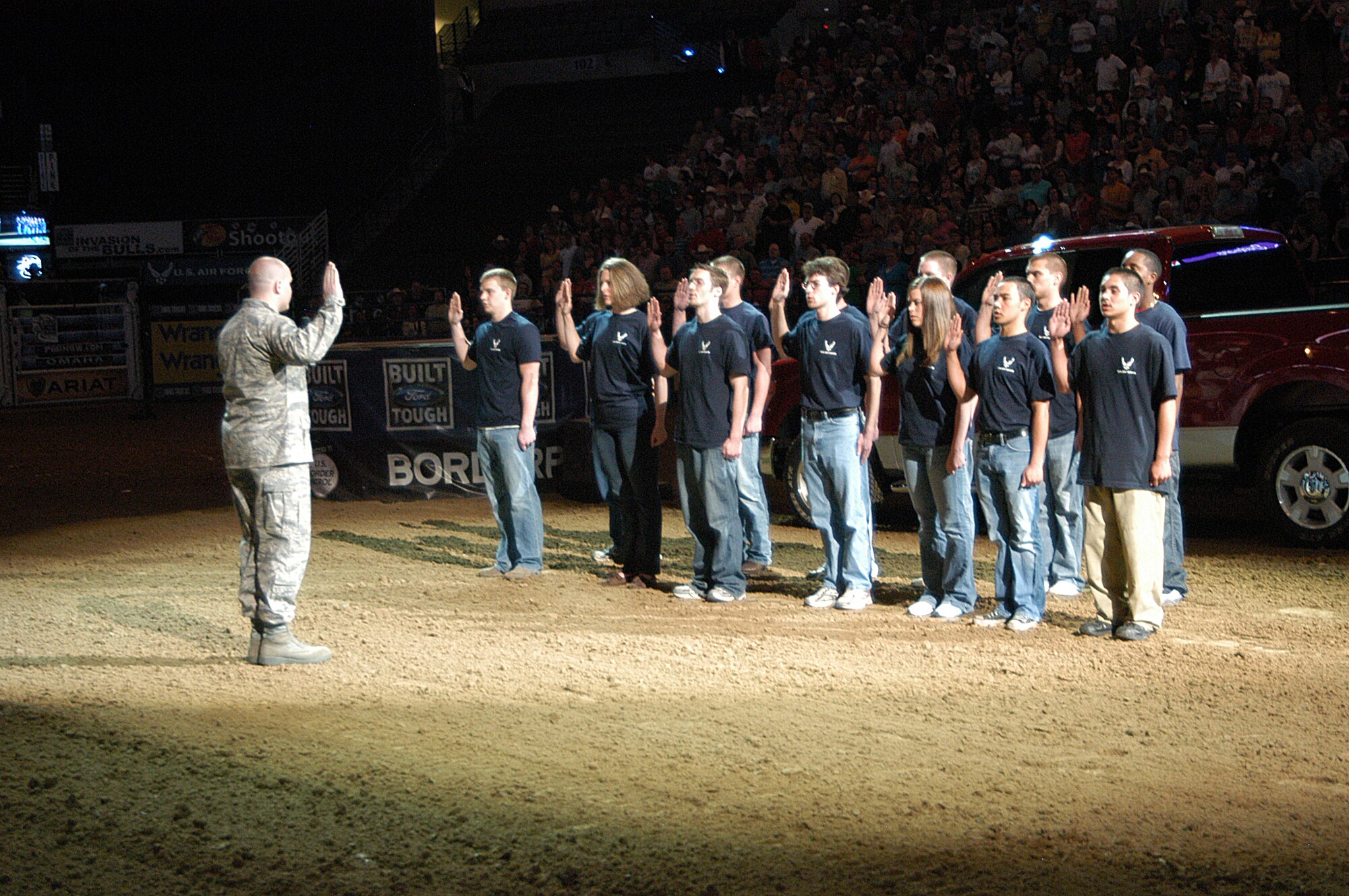 Capt. Michael Kindel administers the Oath of Enlistment to members of the Delayed Entry Program at a Professional Bull Riders Association event April 24, at the Quest Center in Omaha, Neb. Captain Kindel is the 343rd Recruiting Squadron Operations flight commander, headquartered at Offutt Air Force Base, Neb. (U.S. Air Force photo/Tech. Sgt. David McCarrison)