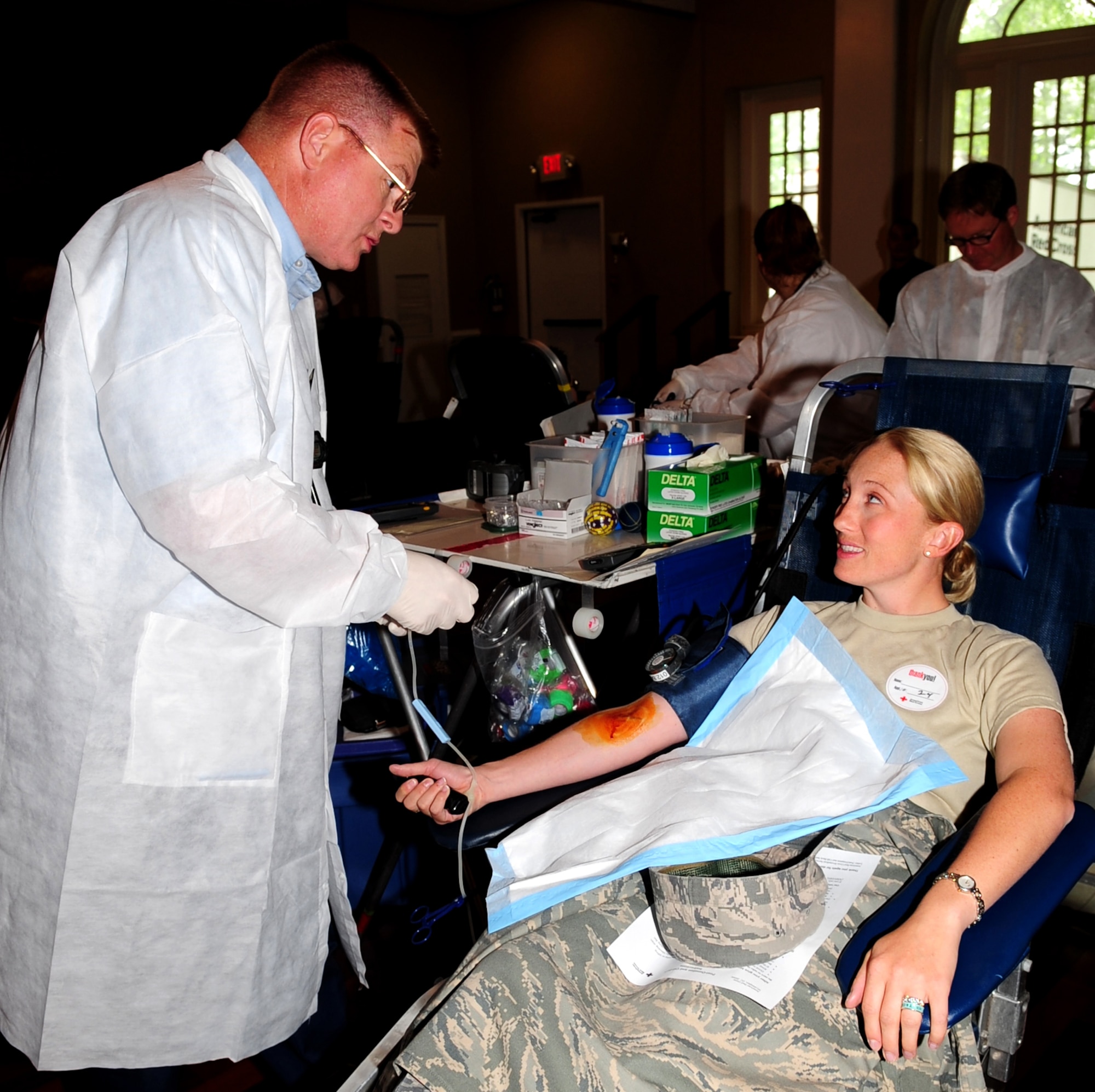 Captain Kristen Duncan, 4th Fighter Wing Public Affairs Chief, listens to the instructions of a phlebotomist while waiting to donate blood during the Red Cross blood drive at Seymour Johnson Air Force Base, N.C., May 7, 2009.  During the drive the Red Cross was looking for type-O blood, which anyone can receive. (U.S. Air Force photo by Airman 1st Class Rae Perry) 