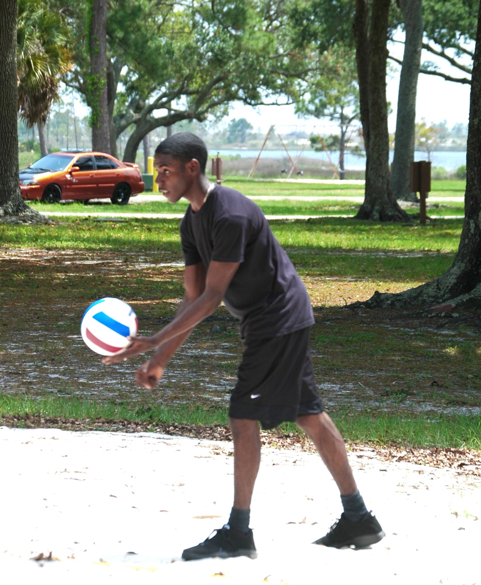 Airman 1st Class Denton Williams prepares to serve during a volleyball game at Heritage Park May 5 in Tyndall Air Force Base, Fla. The volleyball game was hosted by 325th Security Forces Squadron members to provide some extracurricular activity for 10 youths going through rehabilitation at the Liberty Unit for Specialized Treatment program located in Bristol, Fla. Airman Williams is assigned to the 325th SFS. (U.S. Air Force photo/Staff Sgt. Joshua Stevens) 
