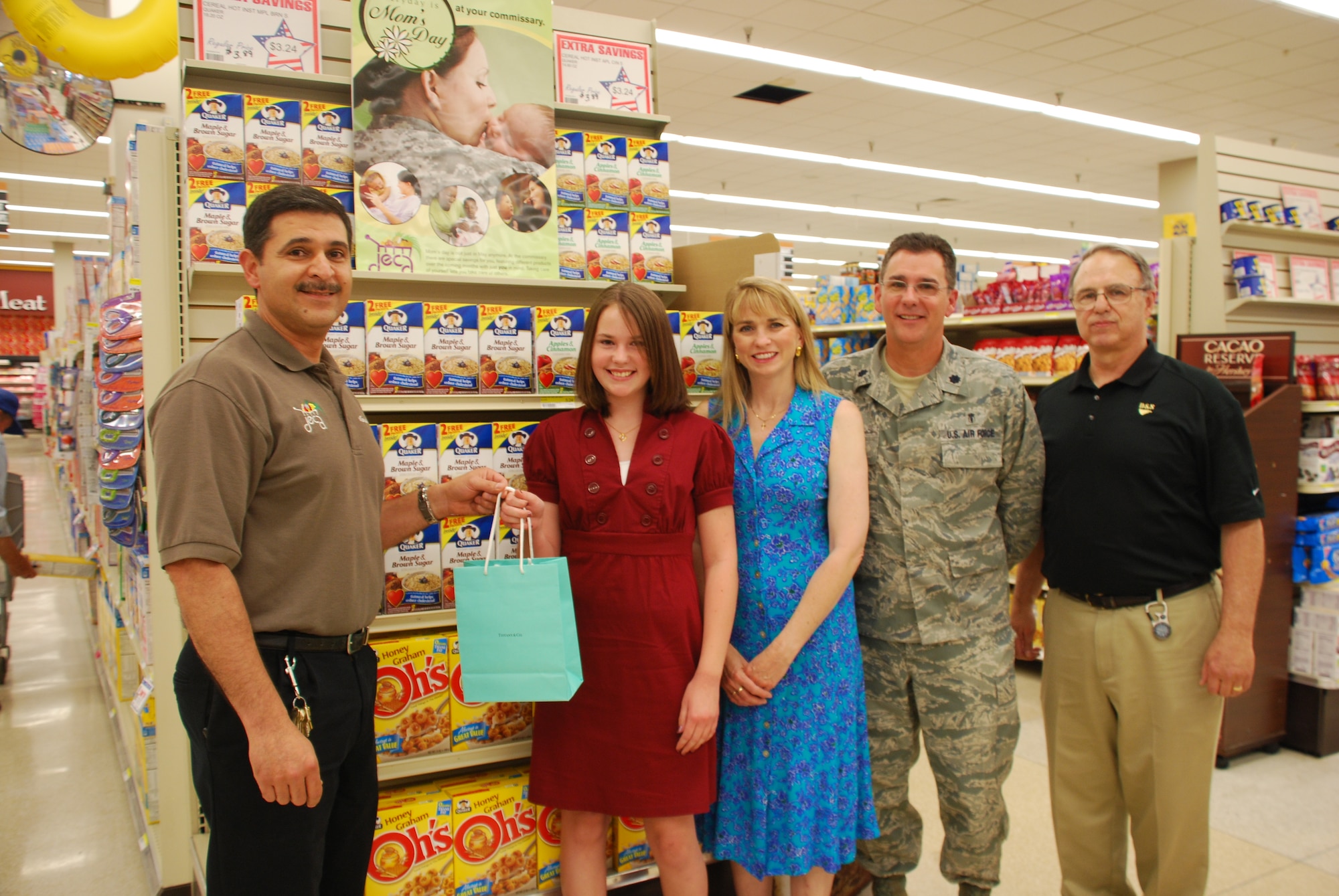 Manuel Othon, store administrator at the Sheppard Commisssary, presents 12-year-old Katie Rice, grand prize winner of Quaker Oat's National Military Mom Essay Contest, with a 500 dollar gift certificate to Tiffany's & Co. May 7. Also pictured are Katies mother, Debbie Rice, Katie's father Lt. Col. Craig Rice, and Quaker representative Scott Levy. (U.S. Air Force photo/Airman 1st Class Candy Miller)