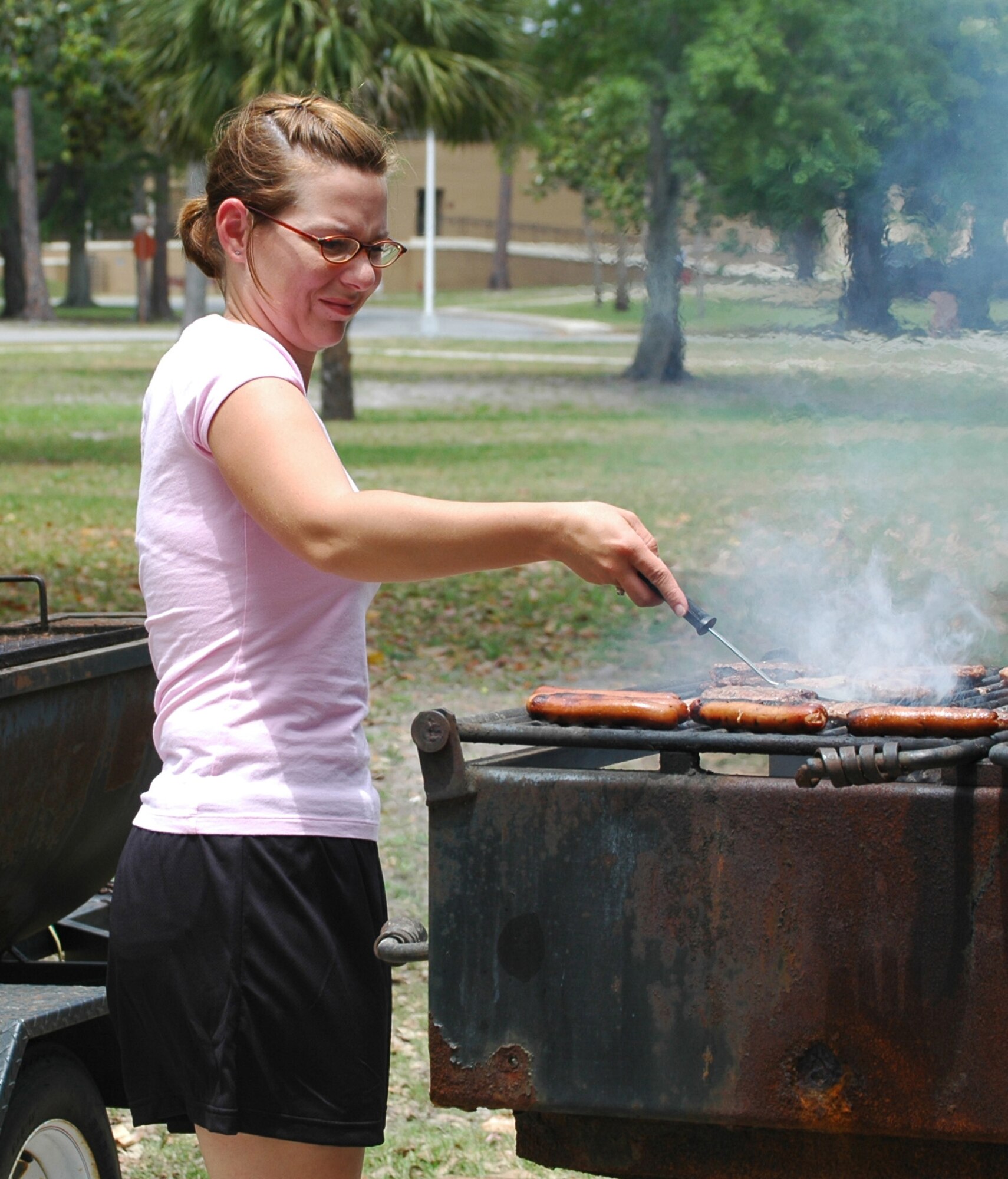 Staff Sgt. Sally Mellen grills hamburgers and hot dogs May 5 at Tyndall Air Force Base, Fla. The lunch was provided to 10 youths involved with the Liberty Unit for Specialized Treatment program from Bristol, Fla. The teenagers were chosen based on their good conduct through the program for a period of at least two months and two weeks. Sergeant Mellen is the 325th Security Forces Squadron command section NCO in charge. (U.S. Air Force photo/Staff Sgt. Joshua Stevens) 
