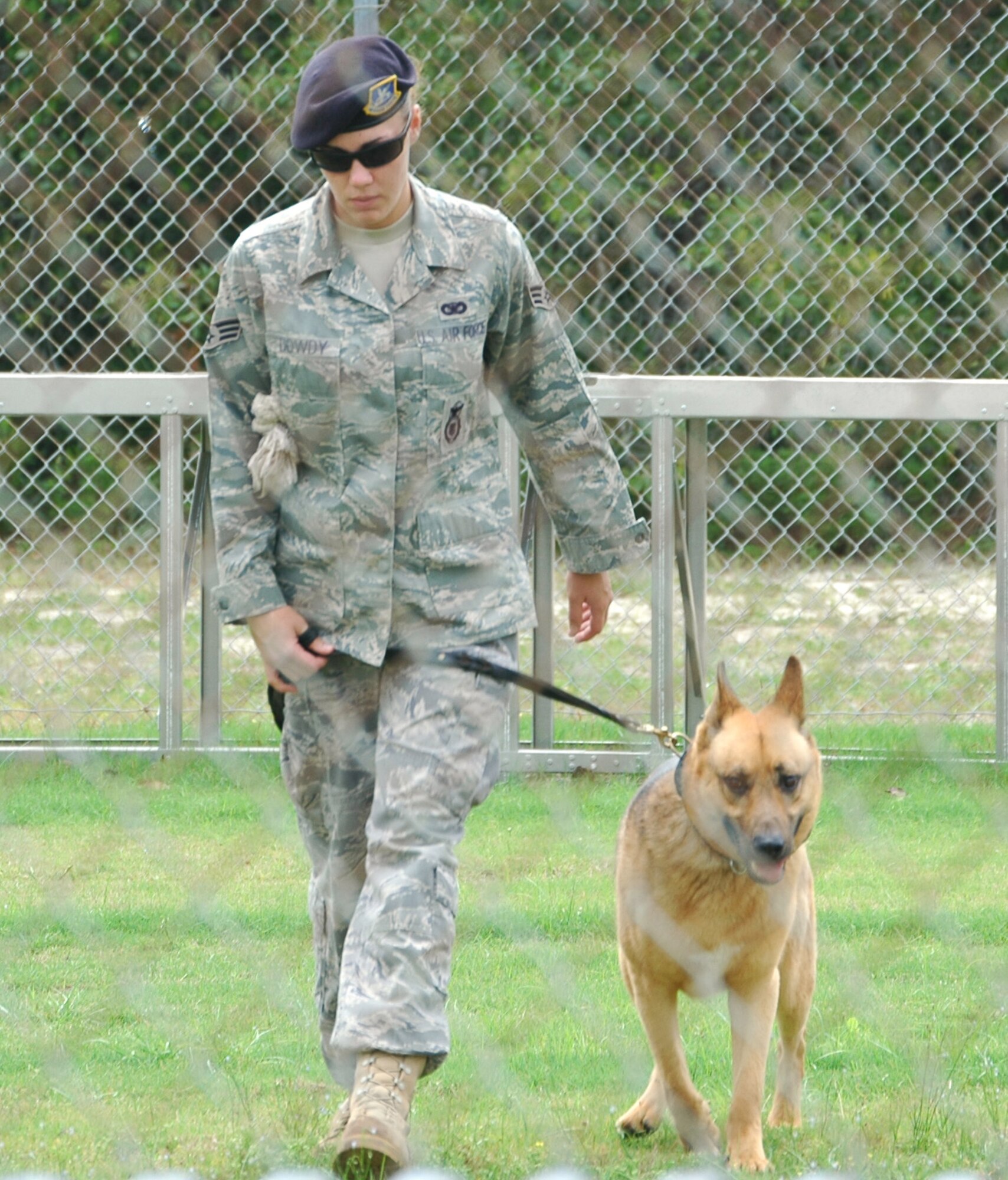Senior Airman Carrie Dowdy guides her dog, Ciro, through a "march" routine to showcase his obedience May 5 at Tyndall Air Force Base, Fla. The audience for the demonstration was made up of youths from Liberty Juvenile Unit for Specialized Treatment in Bristol, Fla. Airman Dowdy is a 325th Security Forces Squadron military working dog handler. (U.S. Air Force photo/Staff Sgt. Joshua Stevens) 
