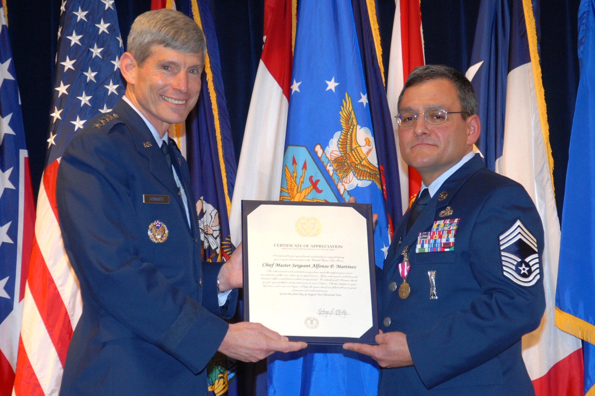 Gen. Norton A. Schwartz, Air Force chief of staff, presents a certificate of appreciation to Chief Master Sgt. Al Martinez, 90th Missile Wing, during Chief Martinez' retirement ceremony May 6 in the Pronghorn Center. (Photo by Berni Ernst)