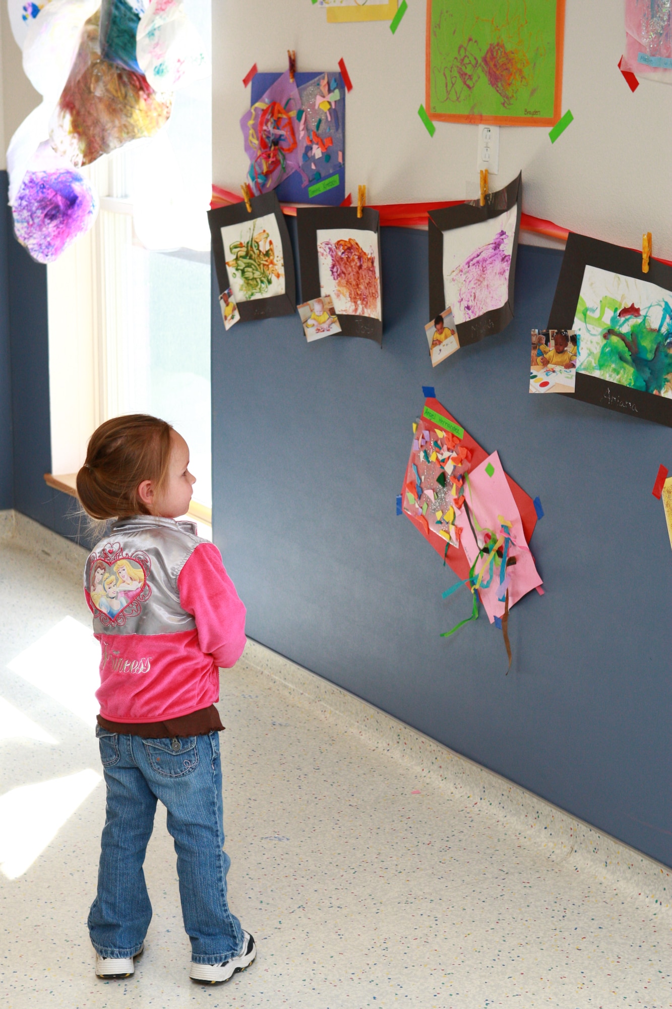 Karlie Shaffer looks at some watercolor paintings displayed during the CDC's art show. During the event, every child, down to as young as 6 weeks old, registrered at the CDC created a piece of art; that means there were 168 pieces of art for the children to show to their parents. (Photo by Jeff Allred)