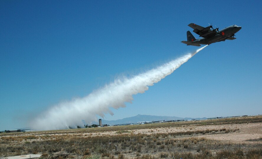 A C-130 Hercules with the Air Force Reserve's 302nd Airlift Wing, Peterson Air Force Base, Colo., drops a load of water from the plane's Military Airborne Fire Fighting System as members of the media look on May 6, 2009, at the Tucson International Airport in Arizona. Tucson was the location for the 2009 MAFFS certification week, May 3-9. (U.S. Air Force photo/Capt. Jody Ritchie)