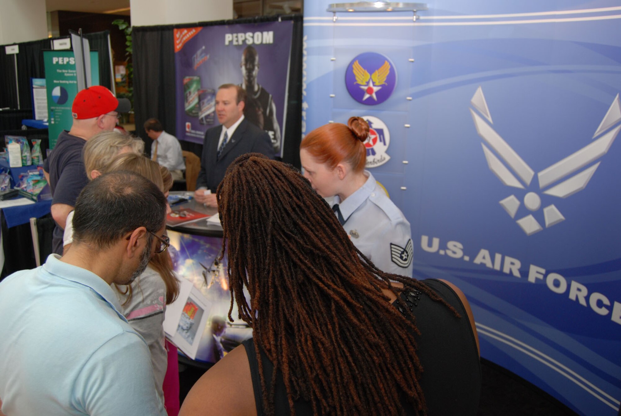 ALEXANDRIA, Va. - Mr. Richard Osburn and Tech. Sgt. Jennifer Buzanowski, Air Force Public Affairs Agency, talk to visitors of the U.S. Patent and Trademark Office's 2009 Expo May 9. The Air Force Trademark and Licensing Office was the first military branch to attend the USPTO's annual expo that drew a crowd of 7,000 people for the two-day event. The U.S. Air Force Band performed during the opening ceremony May 8. (U.S. Air Force Photo/Jessica O'Haver)