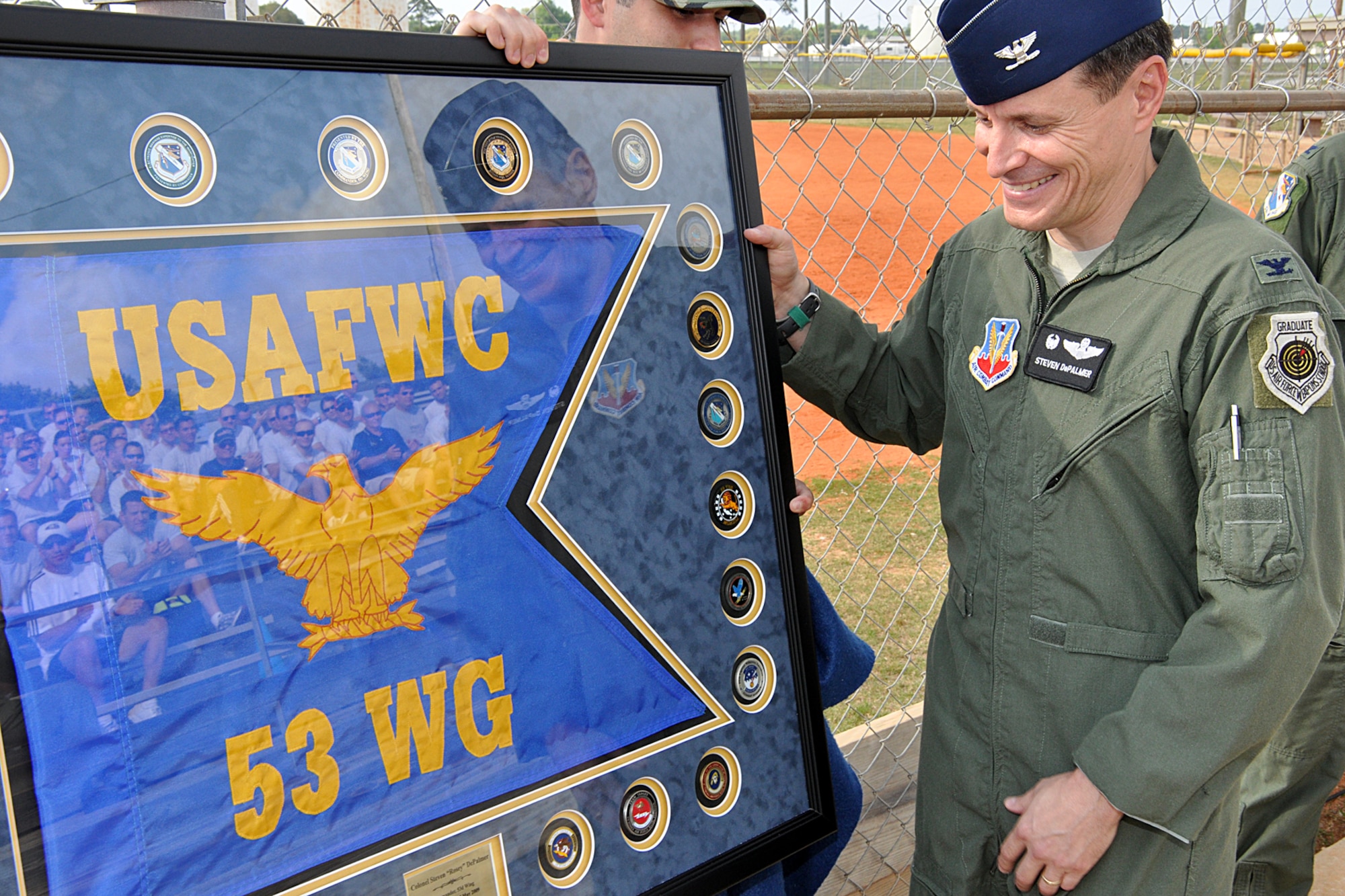 Col. Steve DePalmer, 53rd Wing commander, receives a framed flag memento from the wing during his last commander's call May 8 at Eglin Air Force Base.  For his going away, he held a sports day for the wing with a 1.5 mile run, softball, frisbee, tug-o-war and a burger burn.  Colonel DePalmer departs Eglin for his new assignment as the vice commander of 14th Air Force.  U.S. Air Force photo/Airman Anthony Jennings.