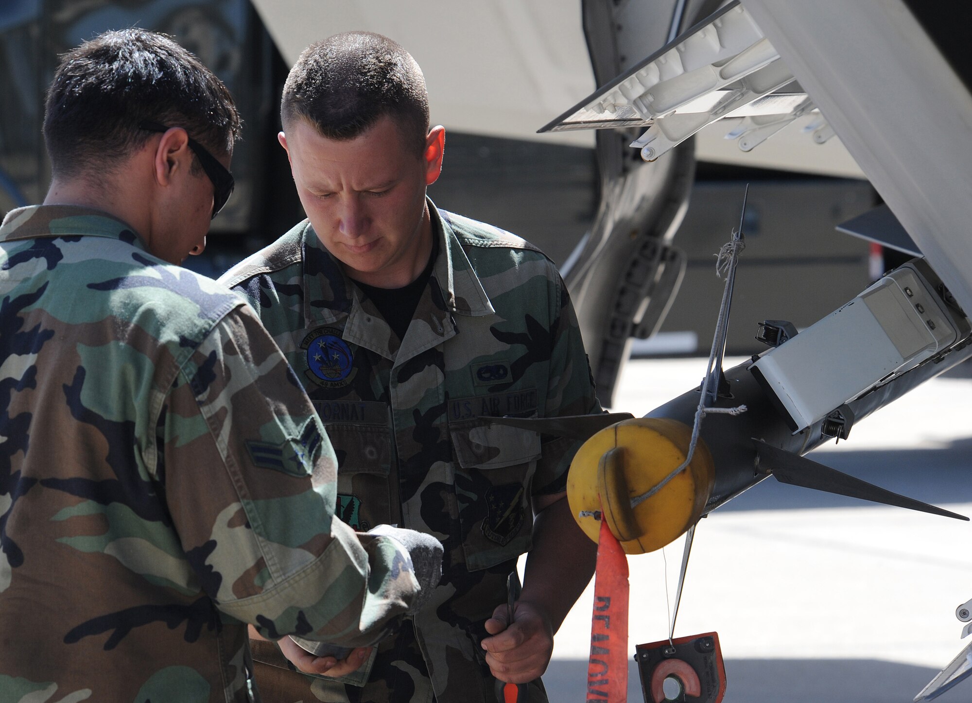 Senior Airman Ray Wornat and Airman 1st Class Carlos Blanco, 49th Aircraft Maintenance Squadron, load an AIM-9 Sidewinder onto the F-22A Raptor, during Combat Hammer at Hill Air Force Base, Utah, May 6. Combat Hammer is a weapons testing program that is apart of the Air Force?s effort to test weapons systems to prepare air crews for upcoming deployments in training missions.
