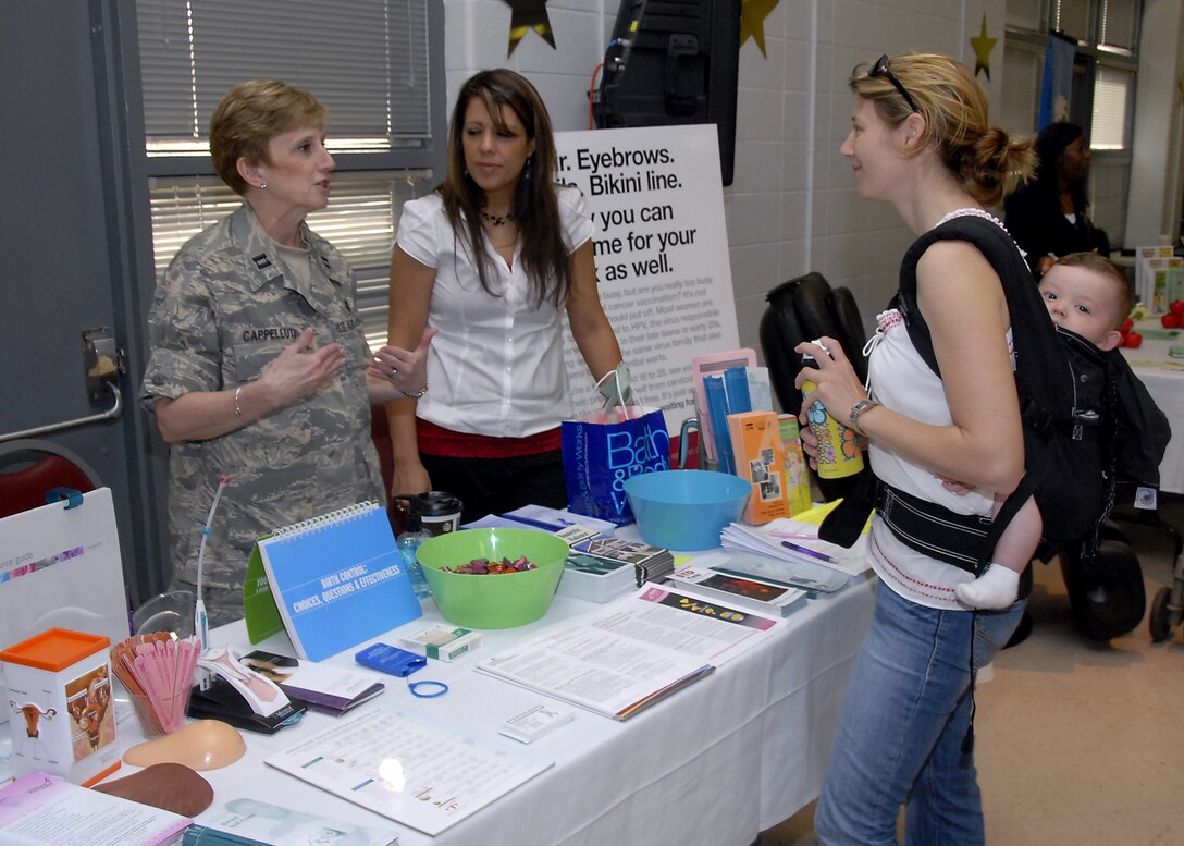 Capt. Lenore Cappelluti, 82nd Medical Group nurse practitioner, and Disease Manager April Coxon explain the Womens Health Booth to Heike Hummel May 8 during Military Spouse Appreciation Day at the community center. Military Spouse Appreciation Day publically recognizes military spouses for their sacrifices for their military family. (U.S. Air Force photo/Mike Litteken)