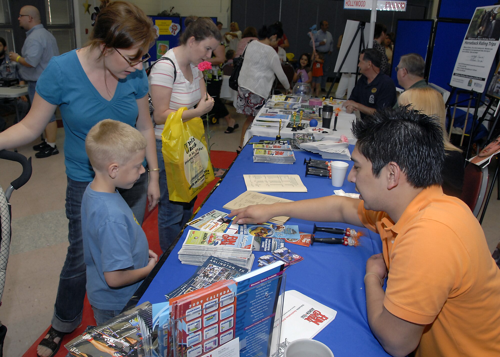Mike Chavez, a tourism Sales Assistant from Arlington, Texas, shows April and Nathan Mathis pamphlets May 8 during Military Spouse Appreciation Day at the community center. Military Spouse Appreciation Day publically recognizes military spouses for their sacrifices for their military family. (U.S. Air Force photo/Mike Litteken)