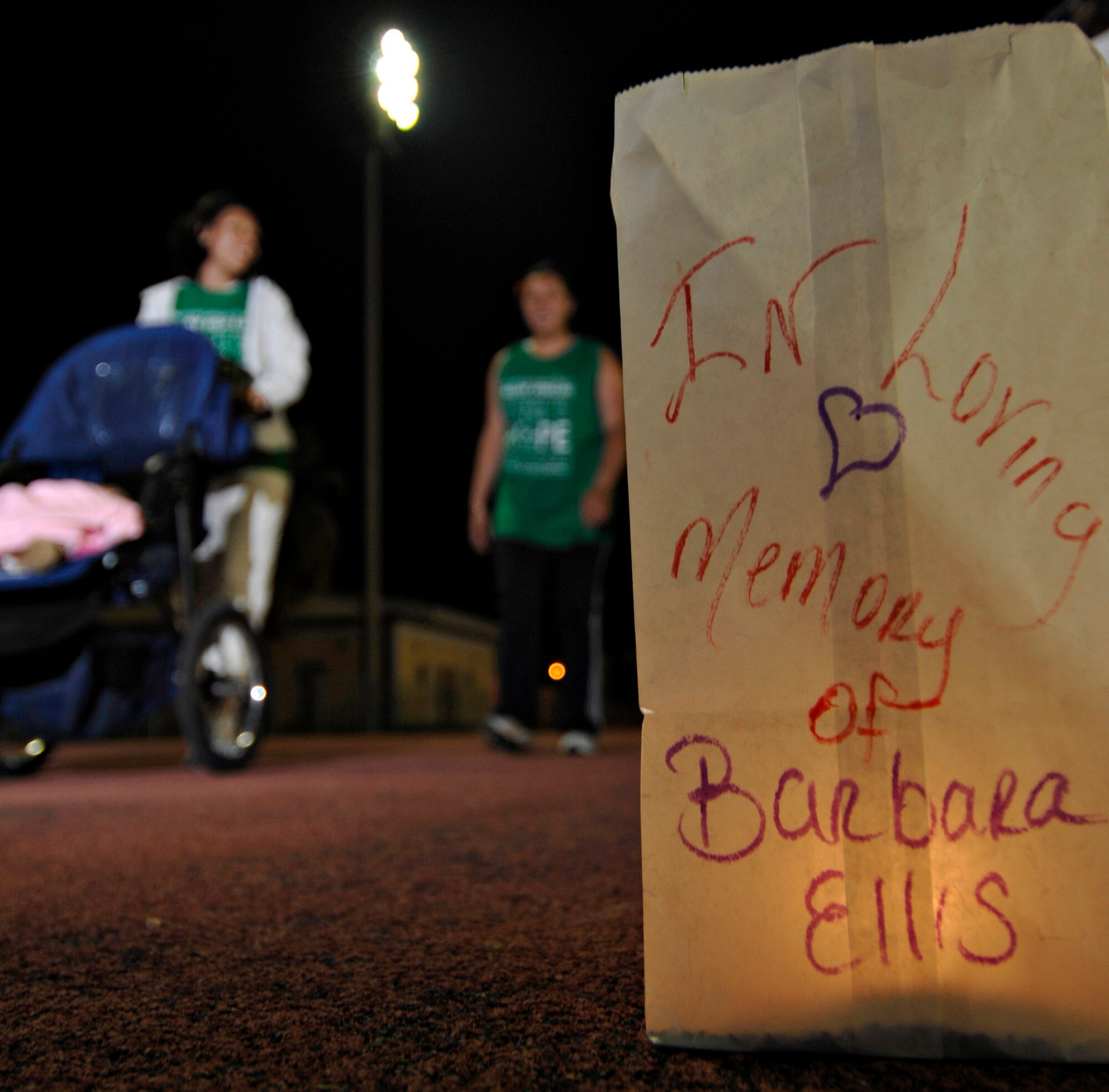 A luminary bags sits lit in memory of Barbara Ellis as participants walk by during the Relay for Life at the Incirlik running track, May 9, 2009. The event lasted 12 hours and included a luminaria ceremony in which participants wrote the names of cancer survivors and victims on more than 100 luminary bags. The 2009 Relay for Life was the first relay available to members of the Incirlik community and hosted more than 300 participants from 20 teams, raising more than $9,500. (U.S. Air Force photo/Senior Airman Benjamin Wilson)