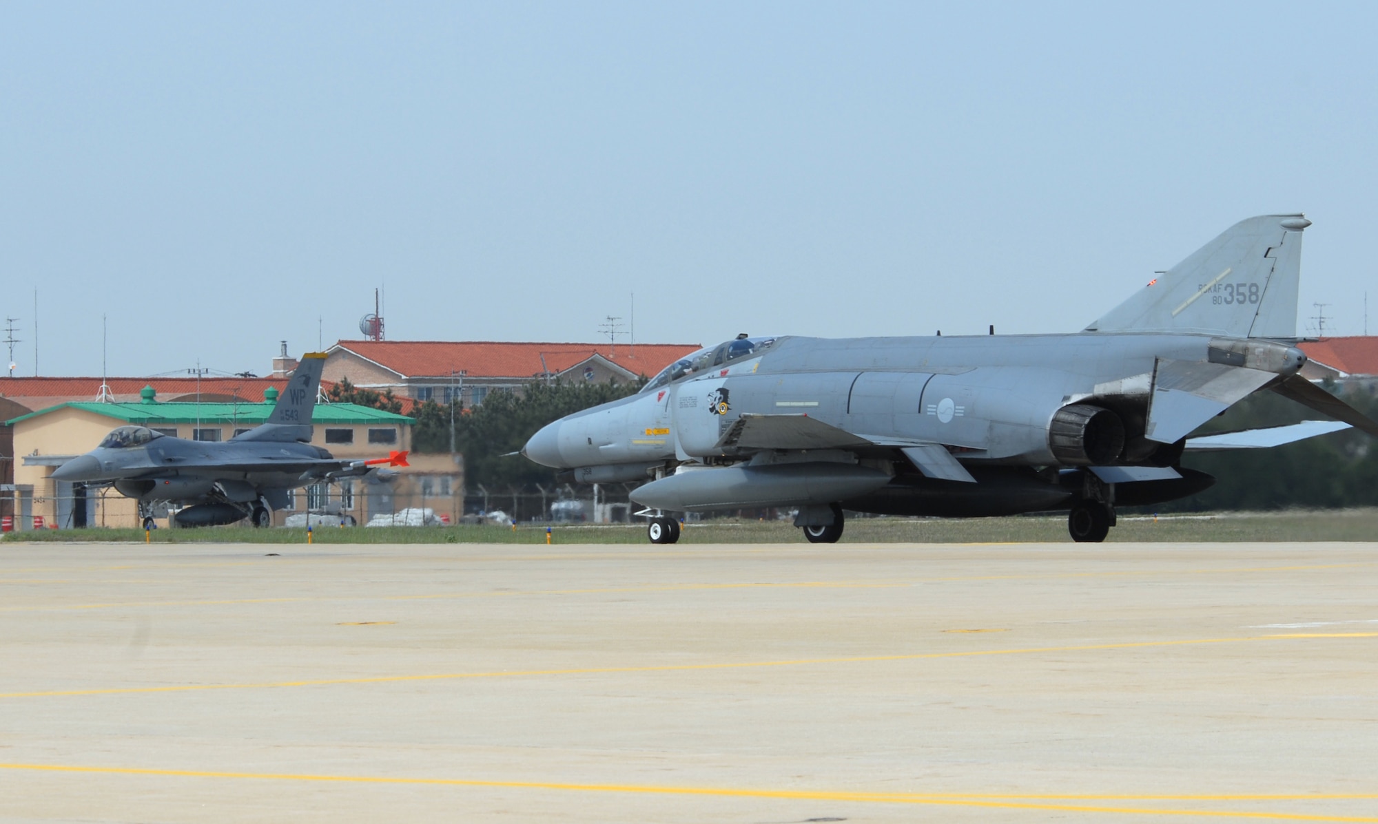 KUNSAN AIR BASE, Republic of Korea -- An F-4E Phantom taxi's by an 80th Fighter Squadron F-16 before take off during exercise Max Thunder 09-01 at Kunsan Air Base, May 11. The second annual Max Thunder exercise is a 7th Air Force-designed, bi-lateral training opportunity that aims to test aircrews' war-fighting skills in realistic combat situations that combine both Republic of Korea Air Force and U.S. Air Force flying and maintenance personnel. (U.S. Air Force Photo/Senior Airman Gustavo Gonzalez)

