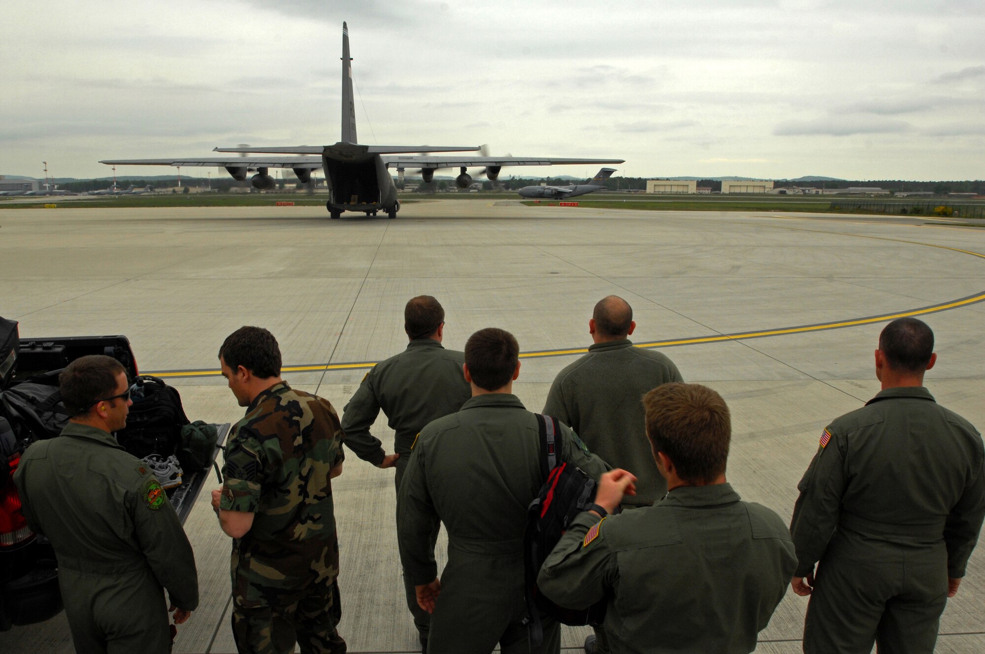 United States Air Force pararescuemen with the 101st Expeditionary Rescue Squadron, New York Air National Guard stand by as a C-130 Hercules from Ramstein Air Base, Germany, taxies onto the hot cargo pad, May 9, 2009, in preparation to be loaded with life saving equipment, in support of NASA in its launch of the space shuttle Atlantis scheduled for May 11, 2009. (U.S. Air Force photo by Senior Airman Kenny Holston)
 
