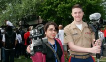 Cpl. Bryan McDonnell, a combat correspondent from Marine Corps Recruiting Command, Quantico, Va., shared information with his Marie Curie High School counterpart, Ana Romero, during a static display at Marie Curie High School here May 11 as part of the inaugural Marine Week Chicago. Romero, an 18-year-old senior at Marie Curie High School, was preparing a news package for the high school television program, 'Radium.' The static display at Chicago's second largest high school was one of the first events of the inaugural Marine Week Chicago. Marine Week Chicago, which runs from May 11-17, is an opportunity for Chicago citizens to meet the men and women of the Marine Corps and learn about its history, traditions and value to the nation.