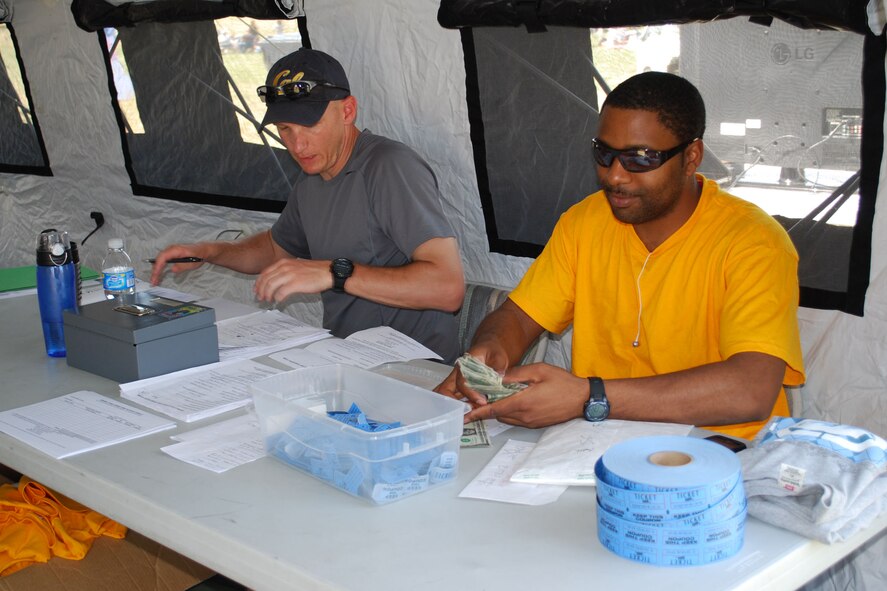 Maj. Jay Johnson, 15th Air Mobility Operations Squadron and Phoenix Mobility intern, and Staff Sgt. Dennis Edwards, 570th Global Mobility Squadron, tally team information and money earned through raffle ticket sales the day of the event.  Nearly 60 volunteers in bright gold t-shirts supported Viking Challenge and helped ensure the event ran smoothly.  Viking Challenge, an annual 12-hour relay event, is the Travis Fisher House’s largest fundraiser each year.  (U.S. Air Force photo/1st Lt. Nicole Langley)