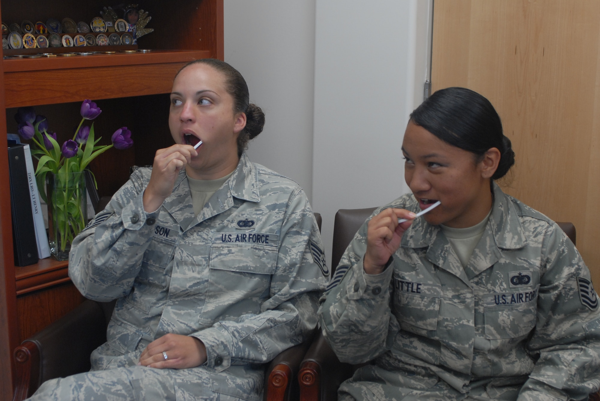 HICKAM AIR FORCE BASE, Hawaii -- Staff Sgt. Ashanti Richardson and Tech. Sgt. Maylene Little, 15th Airlift Wing executive support, swab their cheeks for the bone marrow registry drive here May 12. The drive will continue through June 5, and one out of every 300 registrants will be a match for a patient in need of a bone marrow transplant. The registry process takes about five minutes, but could mean the difference between life and death for a person with a blood disease such as leukemia. (U.S. Air Force photo/Senior Airman Carolyn Viss)