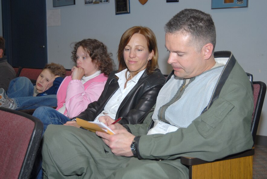 Maj Edmund Figueroa fills out pre-flight paperwork as his wife, Sarah, looks on.  Approximately 15 aircraft took off from Buckley on Tuesday morning.  In total, the flight to Iraq will take more than 20 hours.