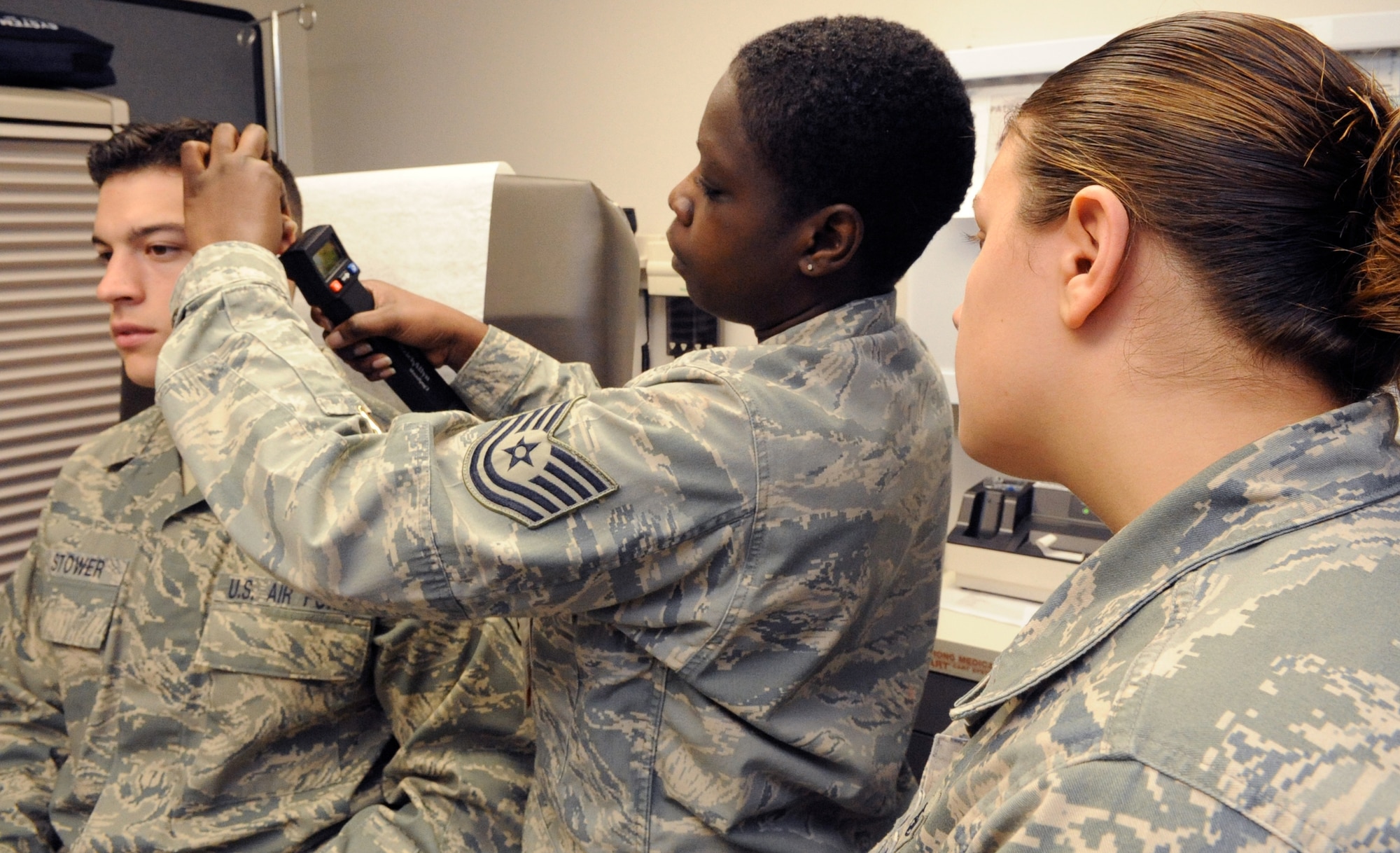NCOIC of Flight Medicine Technical Sgt. Vaisha Harvey, center, of the 87th Medical Group Medical, trains Airman 1st Class Shane Stower, left, and Airman 1st Class Christina Duplease, both Preventive Health Assessment clinic technicians, on the Tympanogram, used to test the condition of the middle ear. (U.S. Air Force photo/Wayne Russell)