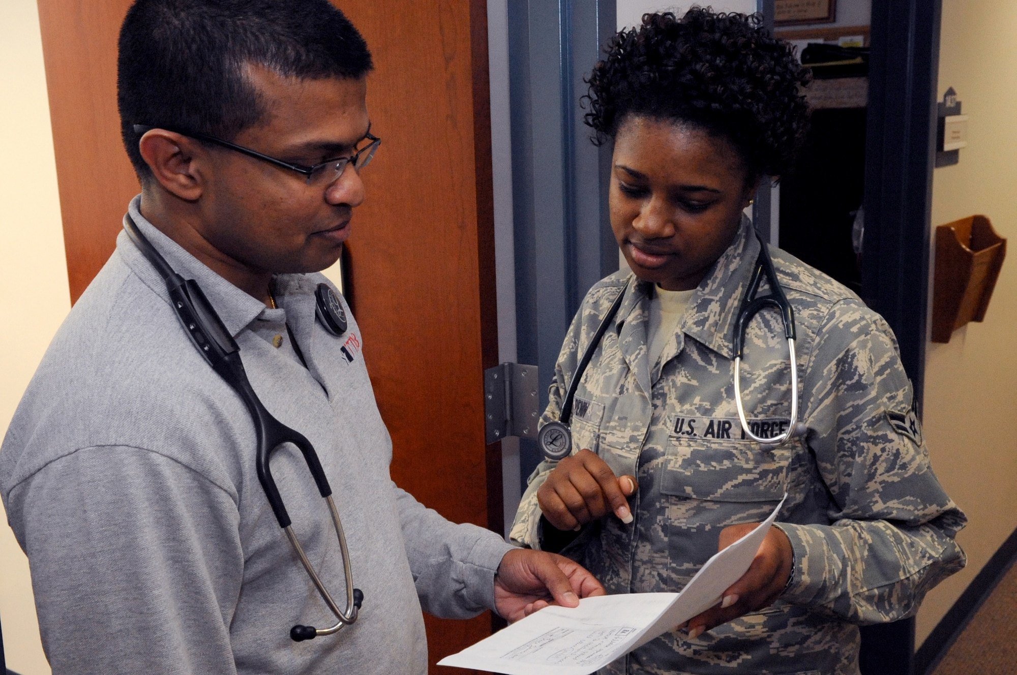 Airman 1st Class Bryanna Penn, a medical technician with the 87th Medical Group, consults with Dr. Aravindan Amuth, a Family Practice physician. The nurses and medical technicians of the 87th MDG are part of the nearly 18,000-member nursing force from the active duty, Air National Guard and Air Force Reserve. (U.S. Air Force photo/Wayne Russell)