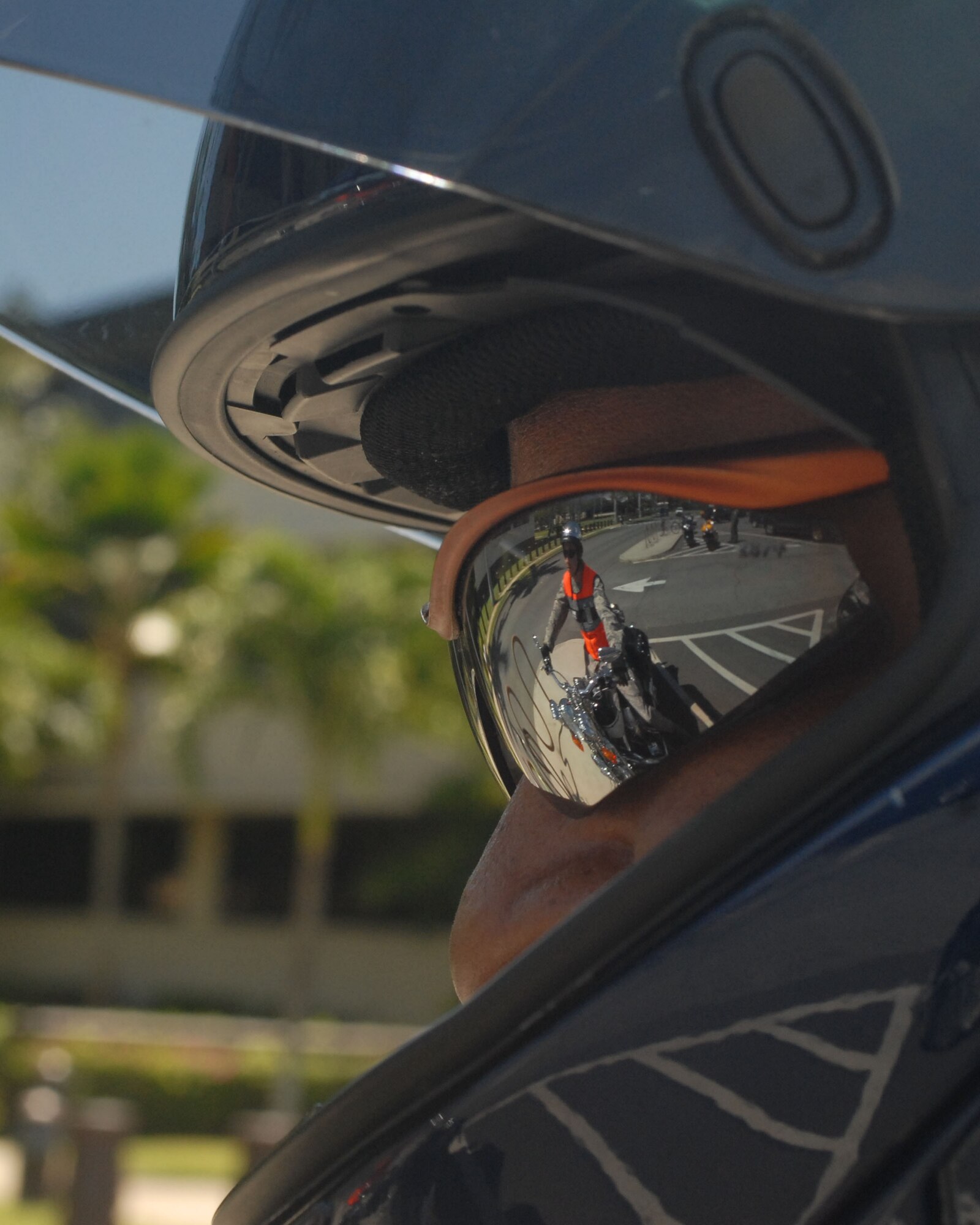 HICKAM AIR FORCE BASE, Hawaii – Daniel Lingham, Jr., watches fellow rider Staff Sgt. Scott Yonushonis (reflected) mount his cruiser wearing proper personal protective equipment outside the 15th Airlift Wing safety office May 12. Both work in the safety office, which is scheduled to host a joint-service motorcycle ride and rodeo here and around Oahu May 22. The purpose of the event is to promote motorcycle safety while building camaraderie among Department of Defense motorcycle riders and potential riders on the island. (U.S. Air Force photo/Senior Airman Carolyn Viss)