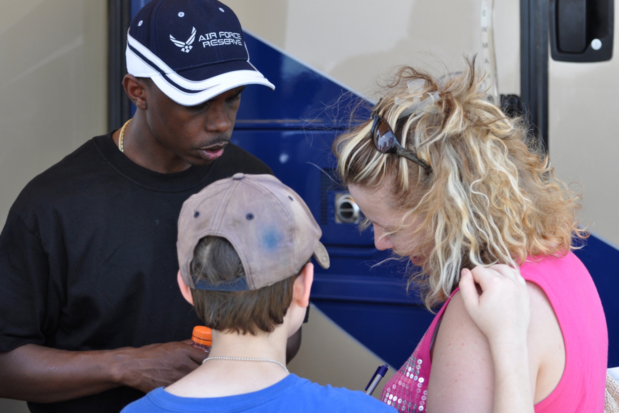 Staff Sgt. Anthony Jones, who is a recruiter with the 917th Wing Recruiting Service, assists a potential recruit fill out the lead form as her son looks on during the Defenders of Liberty Air Show 2009, at Barksdale Air Force Base, La., May 9. Recruiters use activities such as airshows to meet prospective members for the Air Force Reserves. (US Air Force photo/Tech. Sgt. Jeff Walston)