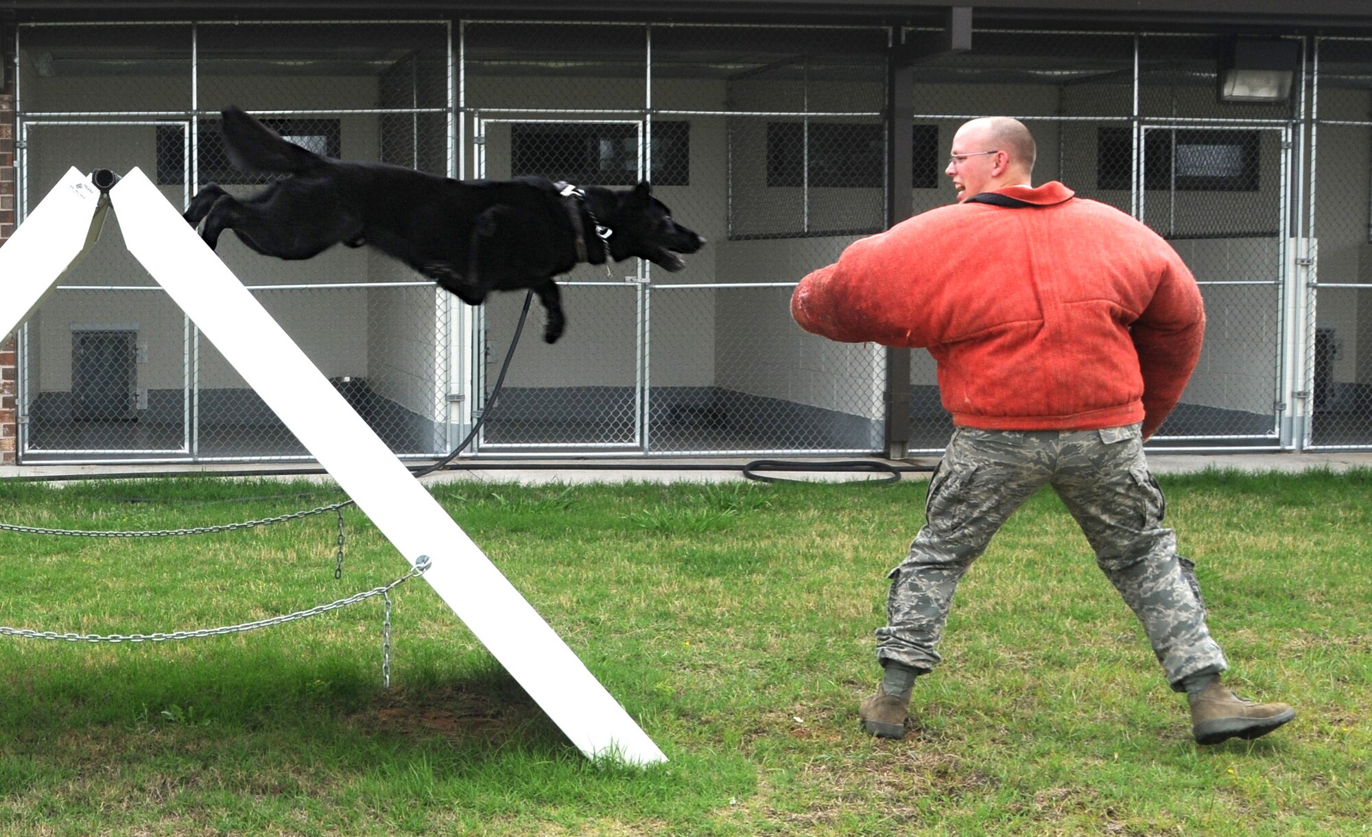 ALTUS AIR FORCE BASE, Okla. – Senior Airman Joshua Newbrey , 97th Security Forces Squadron military working dog handler, stands ready for an attack from a German Sheppard, Asko, during training at an obstacle course on base May 7. The training teaches Asko controlled aggression by simulating obstacles for him to maneuver through. The training will also benefit Asko’s ability to search buildings and apprehend fleeing suspects.  (U.S. Air Force photo/Senior Airman Cherice Bryant)