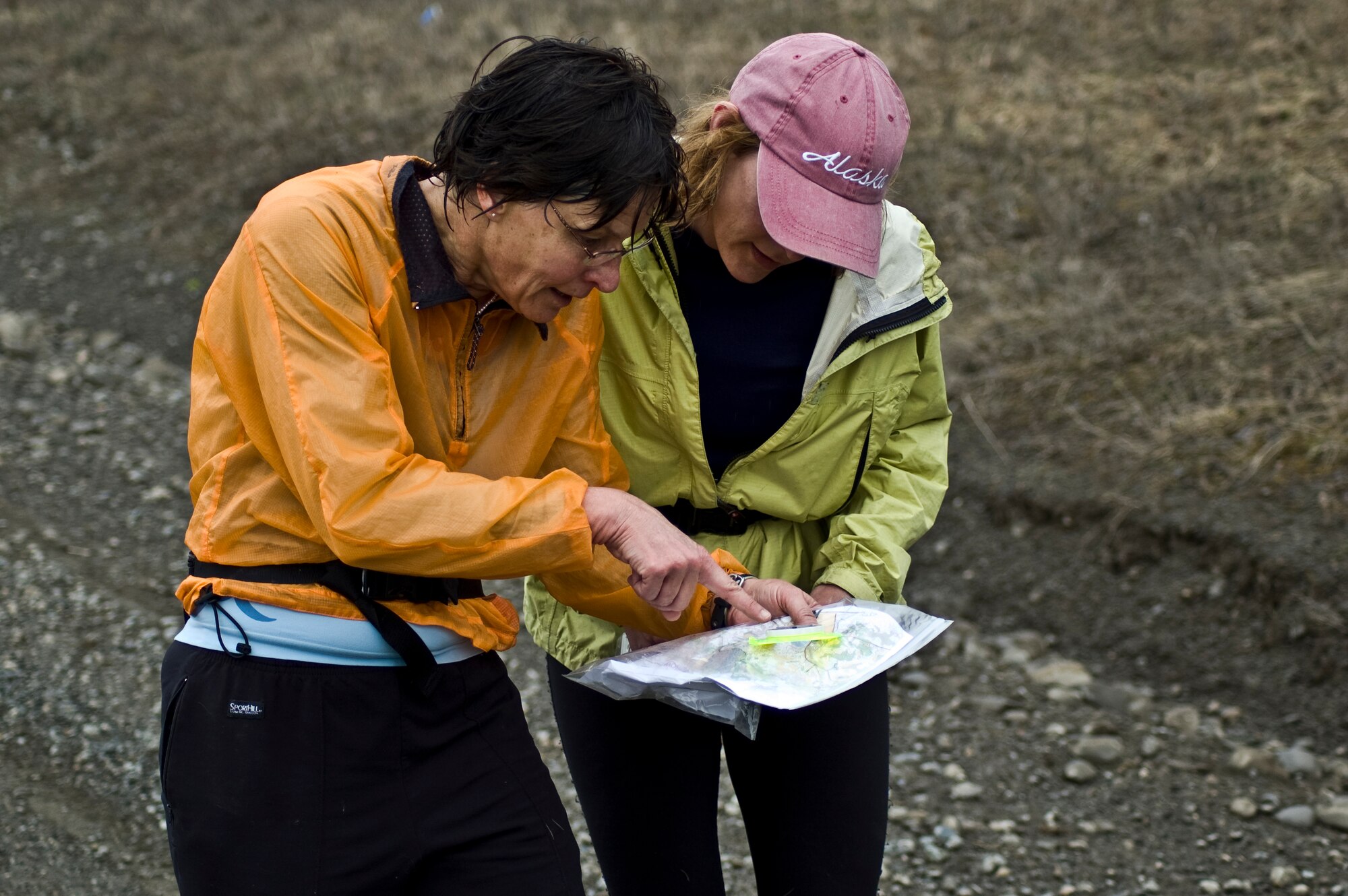 ELMENDORF AIR FORCE BASE, Alaska--Stephanie Martin and Julie Sharp-Dahl both from the Anchorage area read their map to confirm their next destination checkpoint May 6. Martin and Sharp-Dahl are participating in a non-profit orienteering run held here by the  on a rainy afternoon.(U.S. Air Force photo/Airman 1st Class Christopher Gross)  