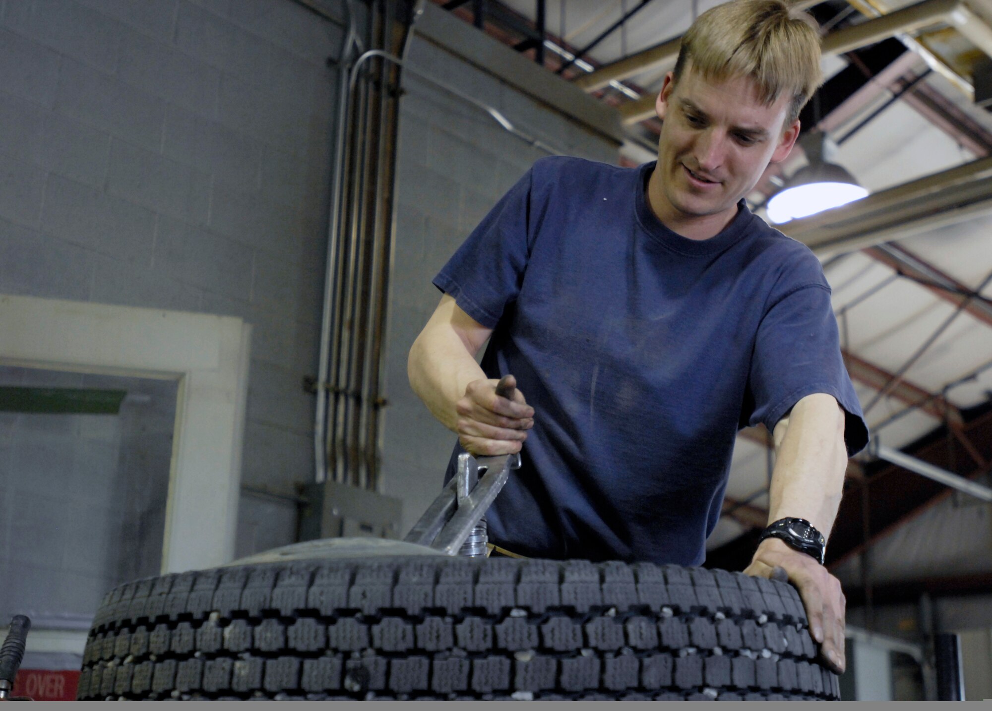 ELMENDORF AIR FORCE BASE, Alaska -- Robert Nelson mounts one of his new summer tires onto a rim in the process of switching out his winter tires for a new summer set. Nelson is a Major for the 210th Reserve Alaska Guard.(U.S. Air Force photo/Airman 1st Class Christopher Gross)