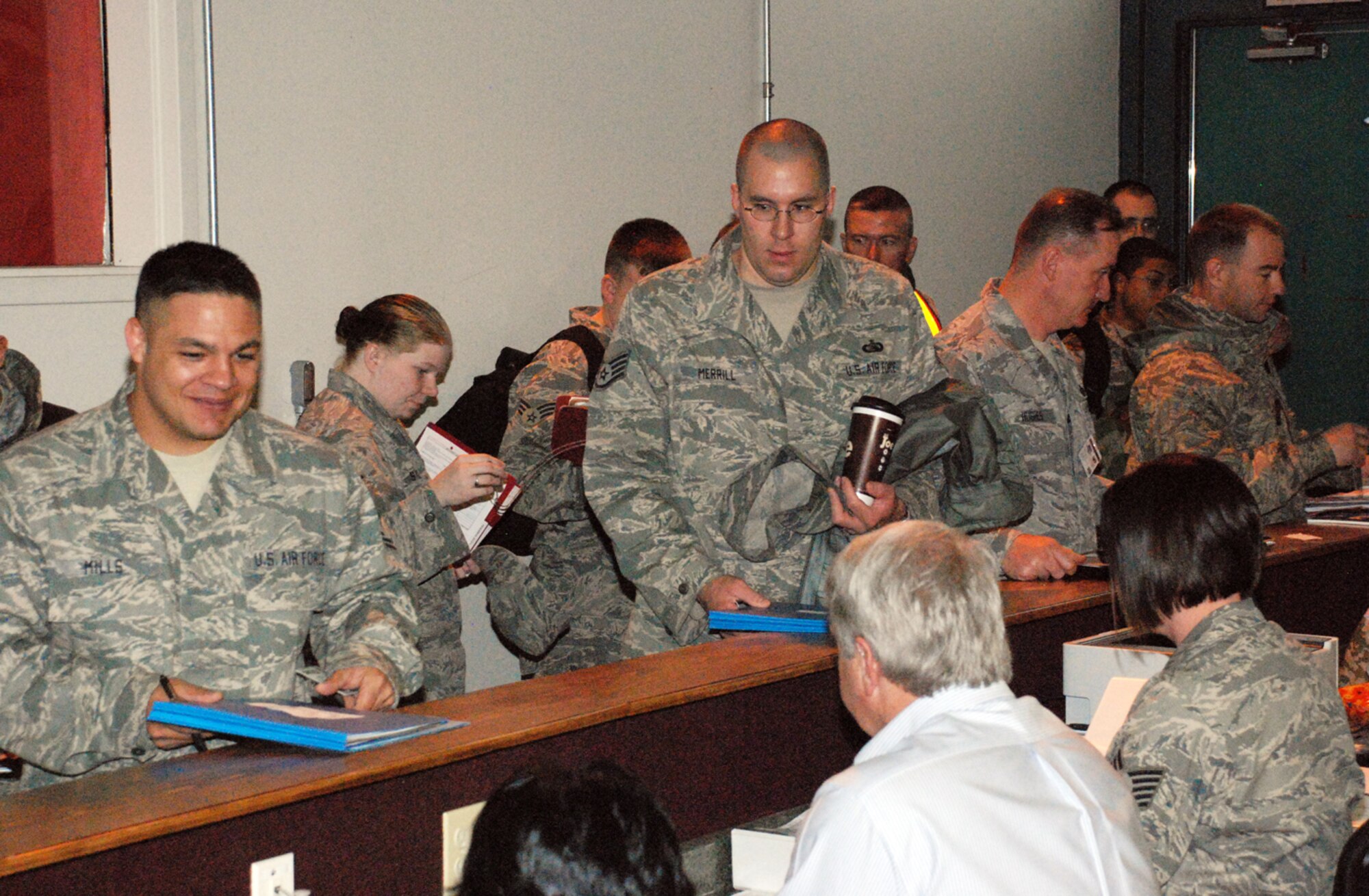 About 30 Warren Airmen walk down an inprocessing line in Bldg. 1284 during a deployment exercise May 1.