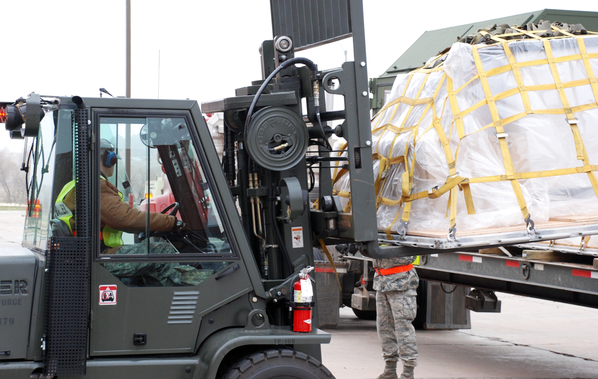 Airman Jones unloads a pallet from a truck during the exercise. After the Airmen unloaded all the cargo, they went through an inprocessing line as if readying the cargo for deployment.