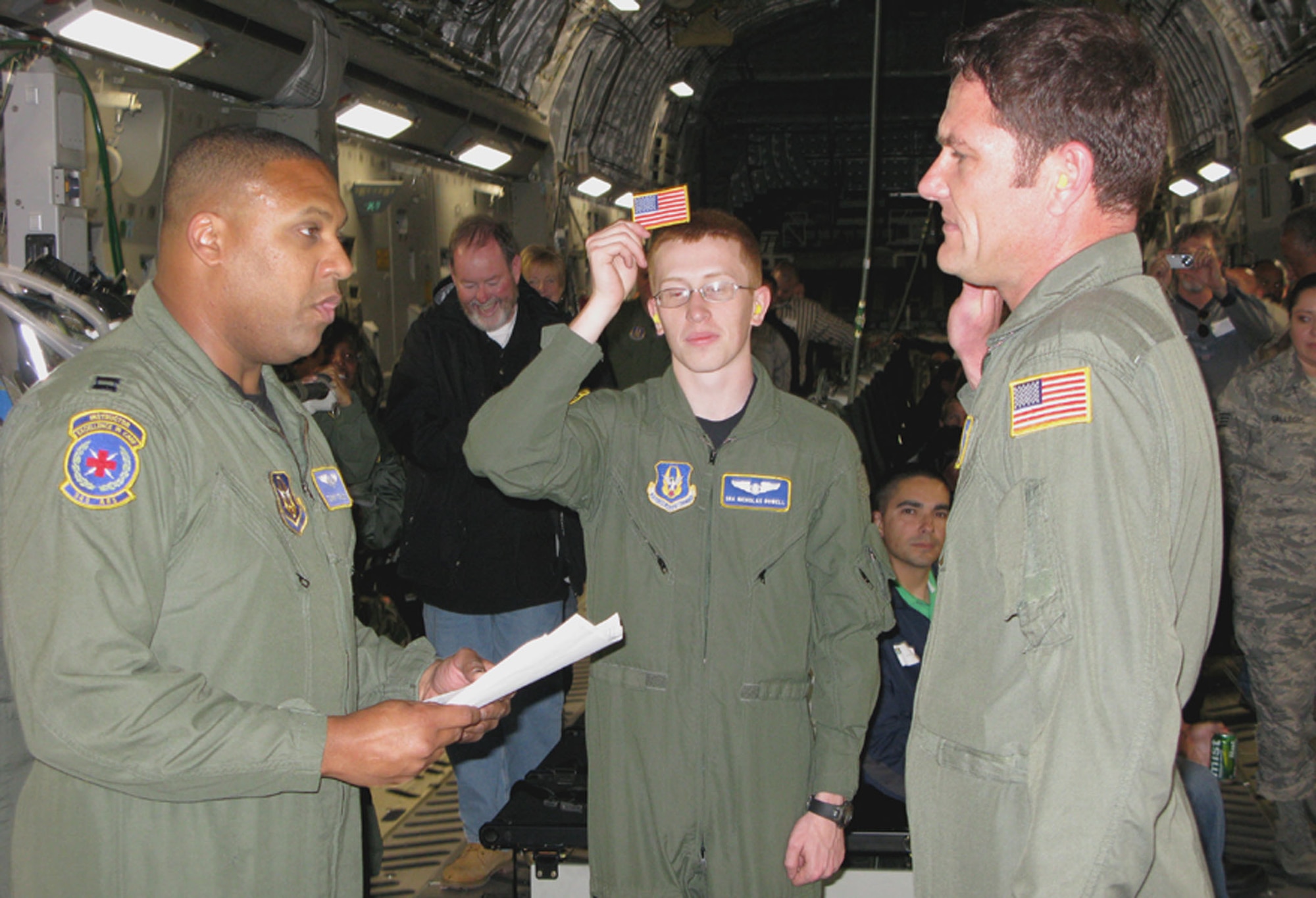 TRAVIS AIR FORCE BASE, Calif. -- Capt. Thomas E. Ferguson Jr., a 349th Aeromedical Evacuation Squadron flight nurse, re-enlists Senior Master Sgt. Alex D. Hellmund, the 349th AES Stan/Eval superintendant, at the conclusion of the 349th Mission Support Group/Operations Group Employer Appreciation flight conducted May 2. (U.S. Air Force photo/Master Sgt. Robert Wade)