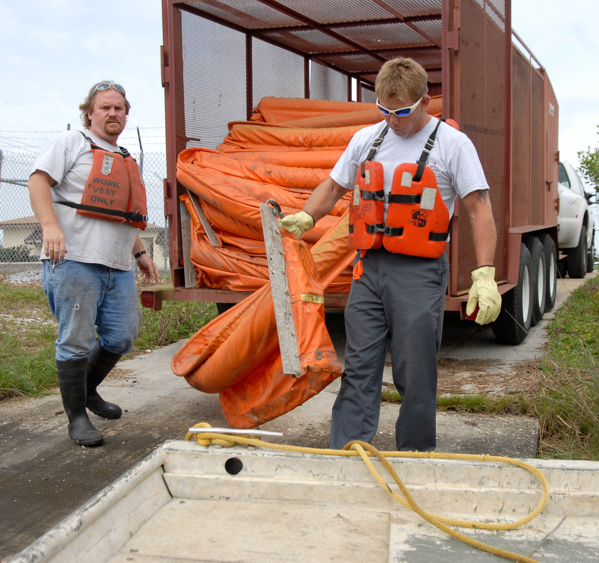 Contracted members of Southern Waste Services, Inc., operated out of Panama City, Fla., begin to attach an oil spill containment boom in order to stretch it across Fred Bayou at Tyndall Air Force Base, Fla., May 12. The boom was necessary for an exercise simulating a spill occuring from tornado damage which resulted from a hurricane. Several base agencies worked together to accomplish the exercise. (U.S. Air Force photo/Robin Walters)