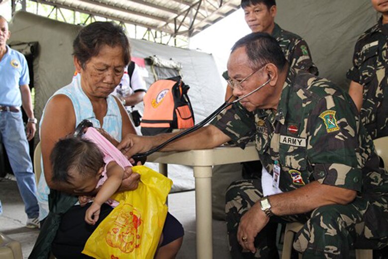 A medic checks the pulse of a Filipino infant patient May 4 during the 2009 Association of Southeast Asian Nations Regional Forum Voluntary Demonstration of Response on Disaster Relief at Sapang Bato, Philippines. Civilian and military medical professionals from the United States, Japan, Australia, Indonesia and Papua-New Guinea are in the Philippines to provide medical care in areas in need. (Courtesy photo) 