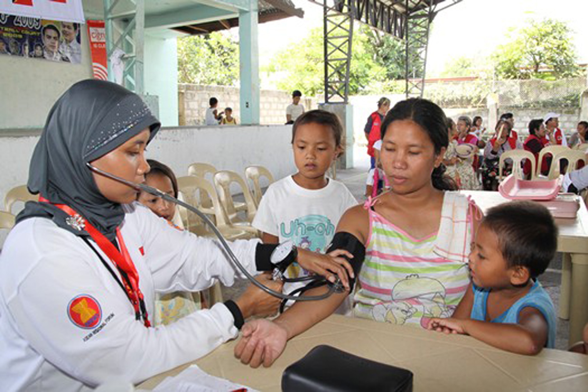 A medic checks the pulse of a Filipino patient during the 2009 Association of Southeast Asian Nations Regional Forum Voluntary Demonstration of Response on Disaster Relief May 4 at Sapang Bato, Philippines. Civilian and military medical professionals from the United States, Japan, Australia, Indonesia and Papua-New Guinea are in the Philippines to provide medical care in areas of need. (Courtesy photo) 