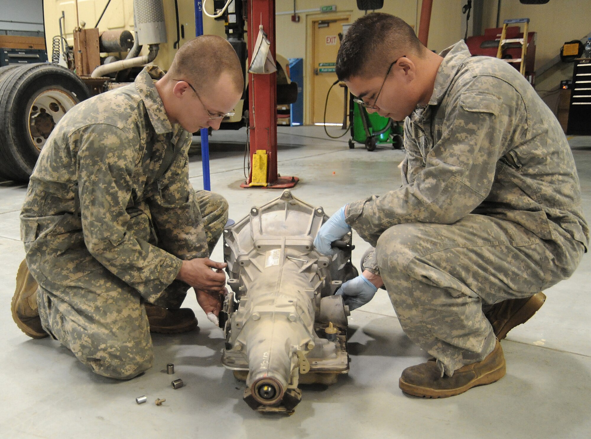 Senior Airman Adam Owens and Senior Airman Michael Jakubec remove brackets and sensors from an old transmission to be used on a new transmission for a Pontiac GTO April 26 at an air base in Southwest Asia. The GTO is used as a chase car to help guide U-2 pilots during takeoffs and landings. Airman Owens is deployed from the 174th Air National Guard Base at Hancock Field, N.Y. Airman Jakubec is deployed from Kadena Air Base, Japan. Airmen Owens and Jakubec are 380th Expeditionary Logistics Readiness Squadron vehicle maintainers. (U.S. Air Force photo/Senior Airman Brian J. Ellis) 
