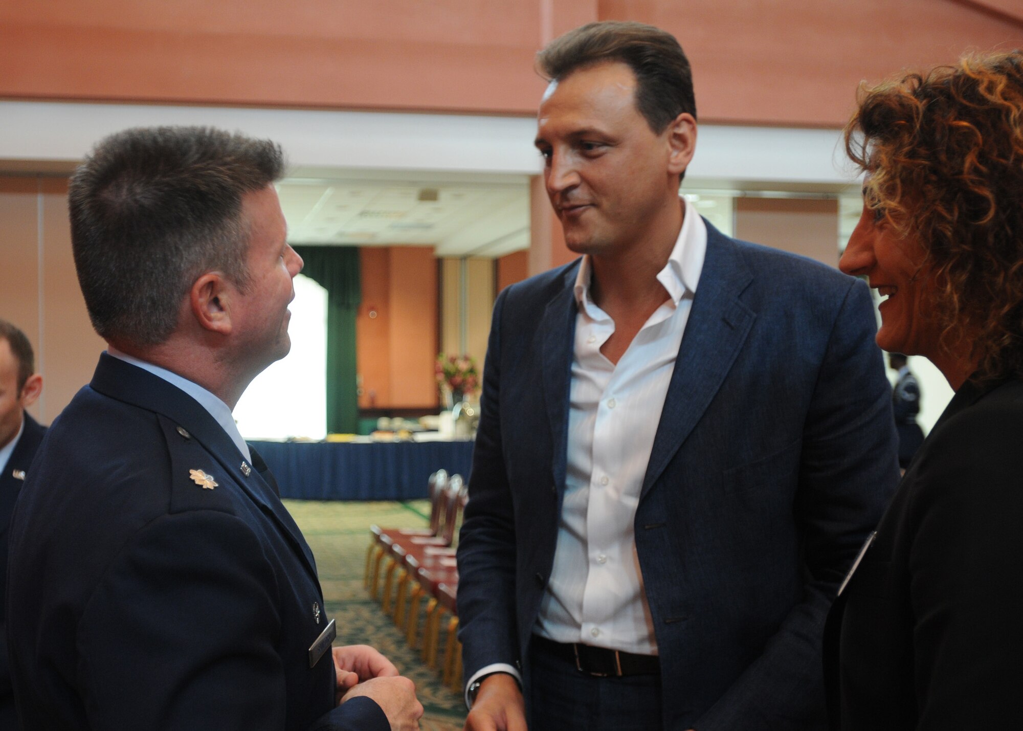 Lt. Col. Matthew Sanford, 31st Aircraft Maintenance Squadron commander, mingles with Mrs. Martina Moritsch and her husband Pierluigi, following Mrs. Moritsch's induction into the 31st Fighter Wing Honorary Squadron Commander Program May 8, 2009, at Aviano Air Base, Italy.  Mrs. Moritsch is the new HSC for the 31st AMXS and is the general manager of Terex Comedil.  (U.S. Air Force photo/Staff Sgt. Patrick Dixon)