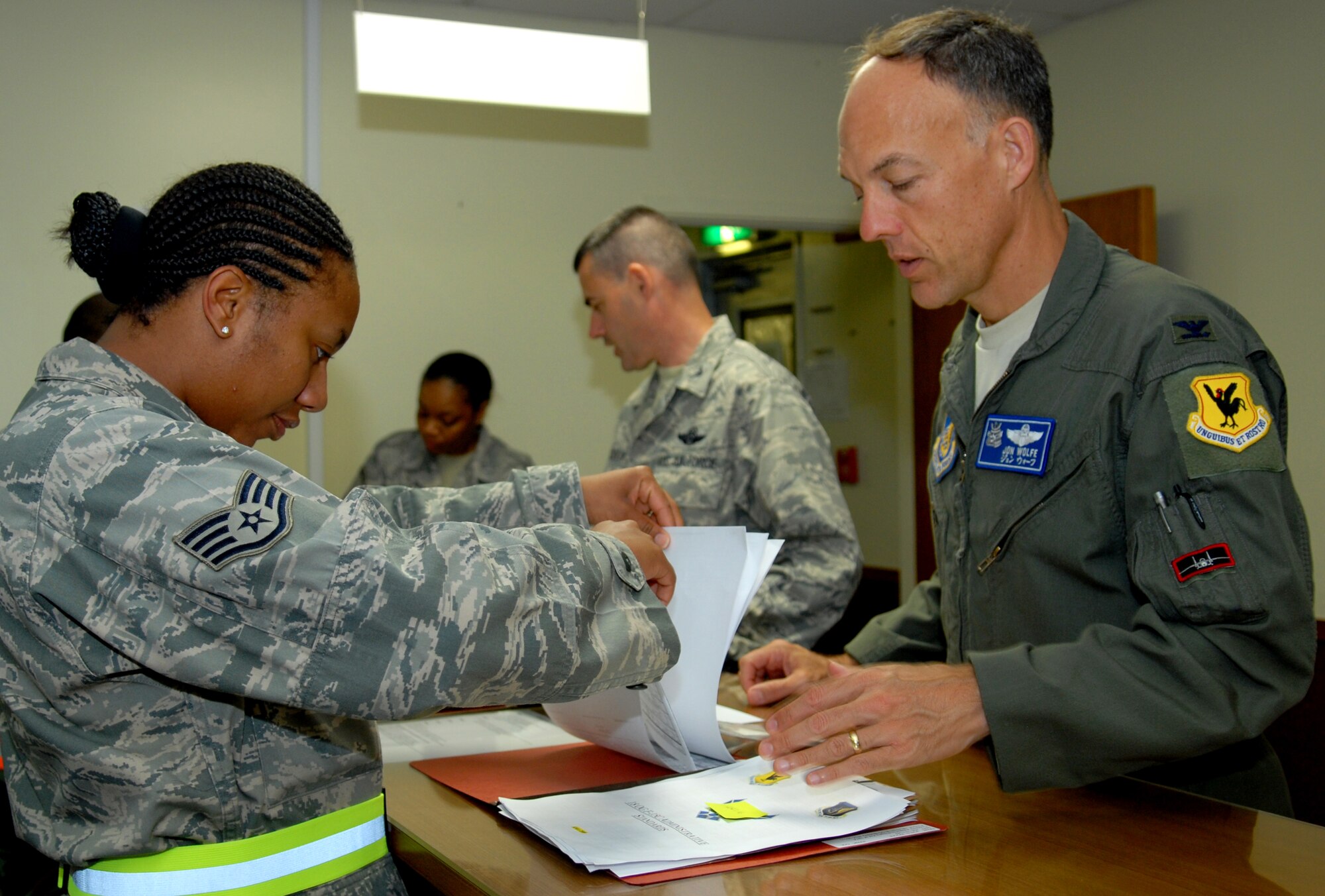 Staff Sgt. Shawn'Tina Williams, from the 18th Force Support Squadron
military personnel section, processes Col. Jon Wolfe, 18th Operations Group deputy commander, and Col. Lenny Richoux, 18th Wing vice commander, through a deployment line during the Beverly High 09-2 Local Operational Readiness Exercise May 12. The LORE tests base personnel on their combat readiness for real world emergency/combat events. (U.S. Air Force photo/Tech. Sgt. Angelique Perez)