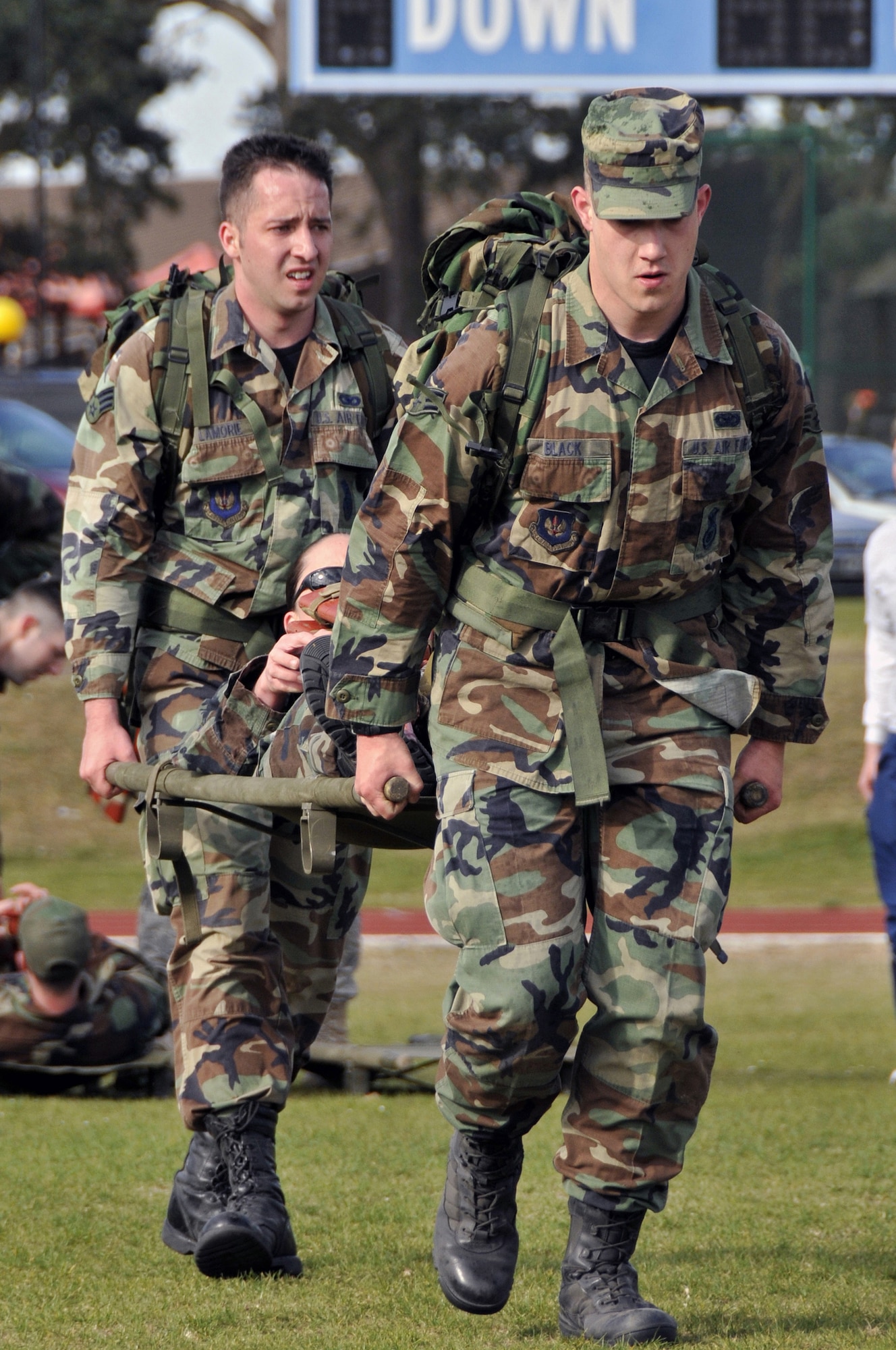 ROYAL AIR FORCE LAKENHEATH, England -- Senior Airman Alan Black and Senior Airman Brian Lamorie carry Staff Sgt. Jessica Gibson, 48th Security Forces Squadron, during the 5K Ruck March May 11, 2009. The litter carry was the obstacle during the 5k Ruck march for The 2009 National Police Week.  (U.S. Air Force photo by Airman 1st Class Perry Aston) 