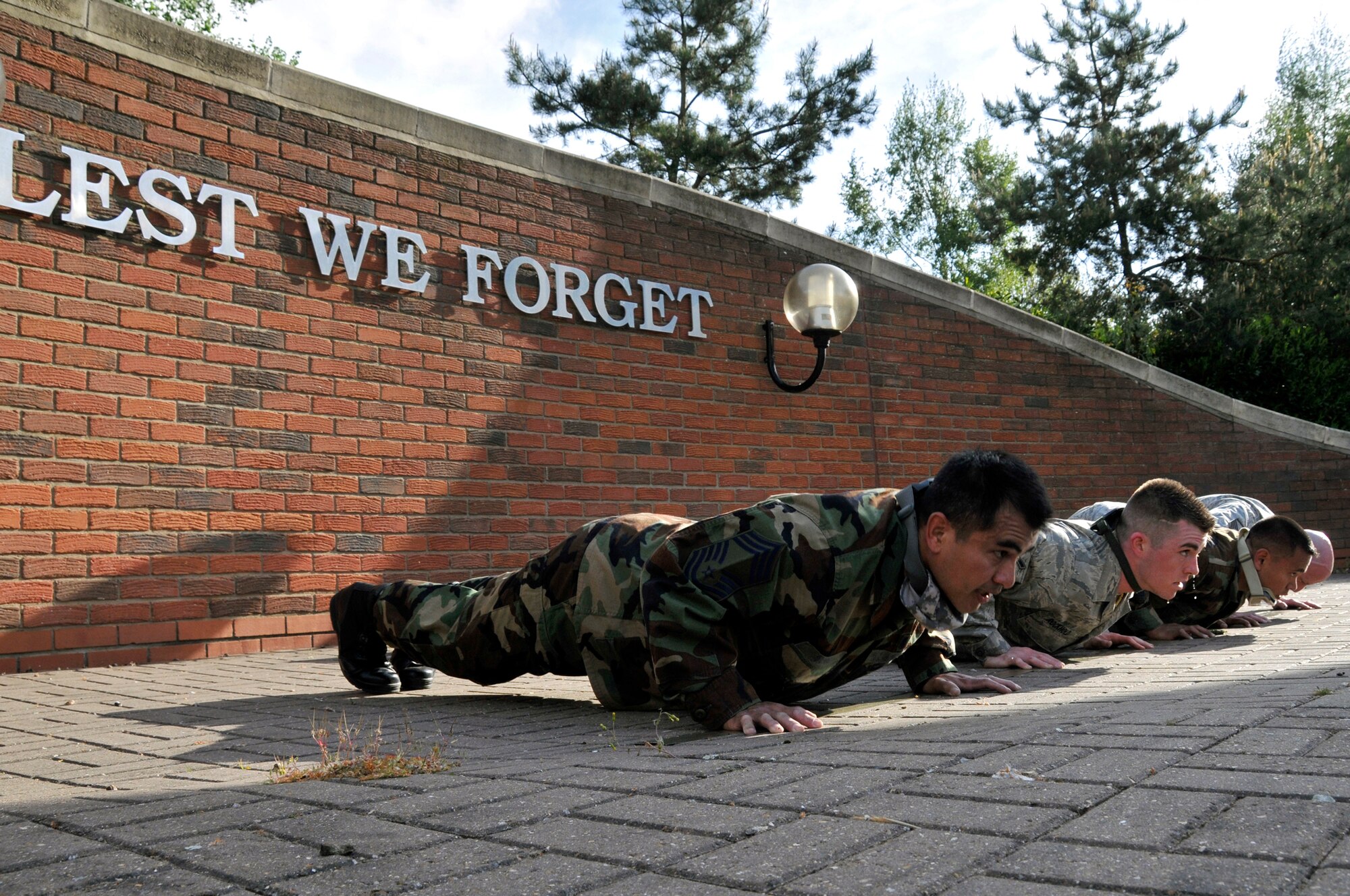 ROYAL AIR FORCE LAKENHEATH, England -- Airmen perform ten, four count pushups in front of the "Lest We Forget" memorial park, May 11, 2009. Pushups were one of several tasks during the 5K Ruck March for 2009 National Police Week May 11 to 15.  (U.S. Air Force photo by Airman 1st Class Perry Aston) 