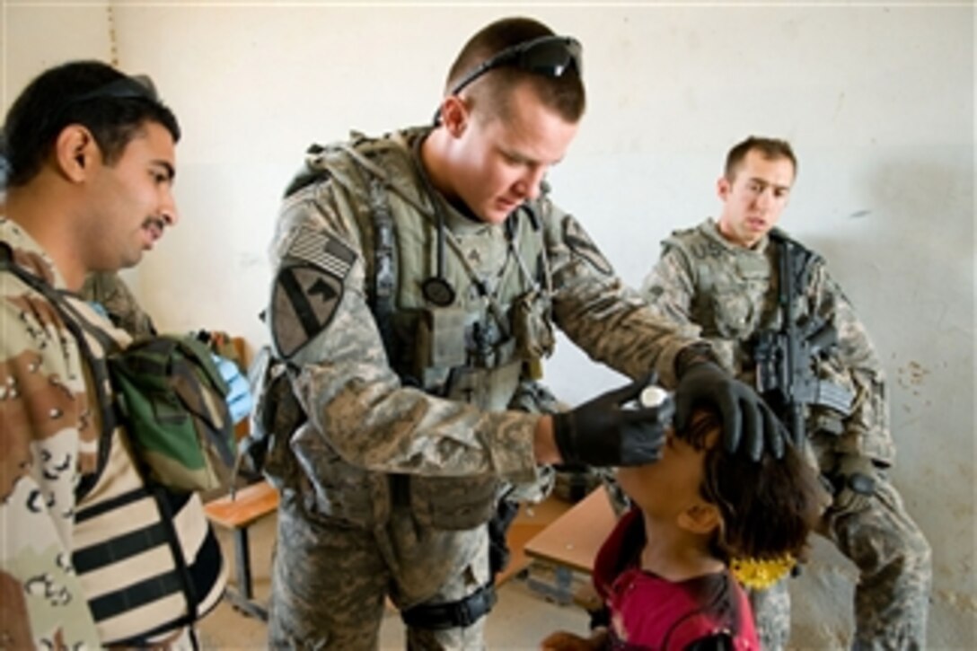 U.S. Army Sgt. Craig Wayman puts eye drops into an Iraqi girl's eye during a combined medical evaluation in a village in Kirkuk, Iraq, on May 7, 2009.  Wayman is a combat medic attached to Charlie Troop, 4th Squadron, 9th Cavalry Regiment, 2nd Heavy Brigade Combat Team, 1st Cavalry Division.  